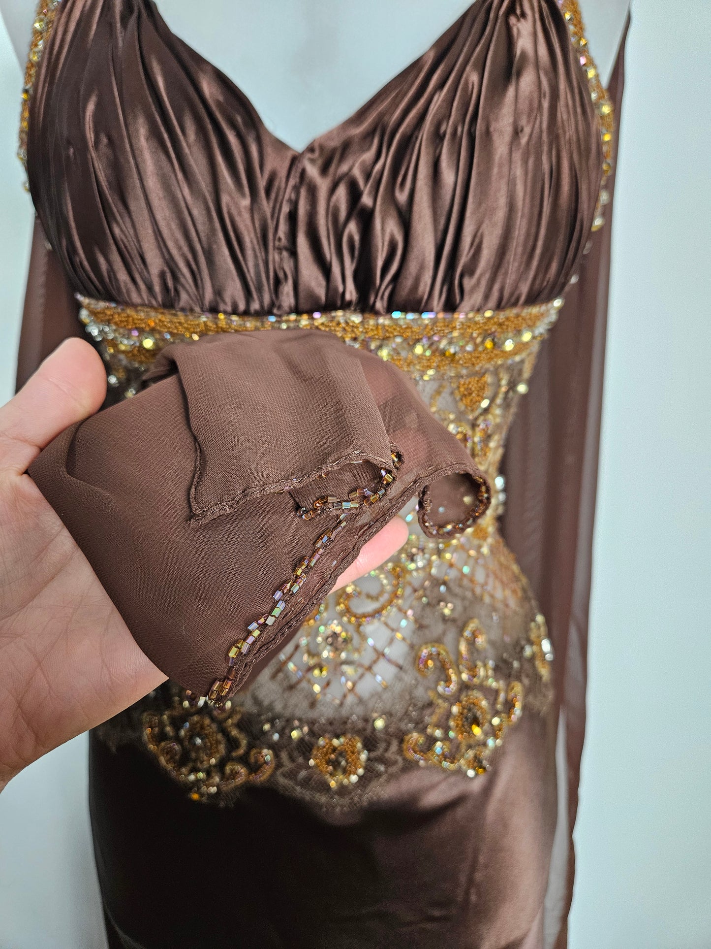 Vestido marrón de satén y perlas.