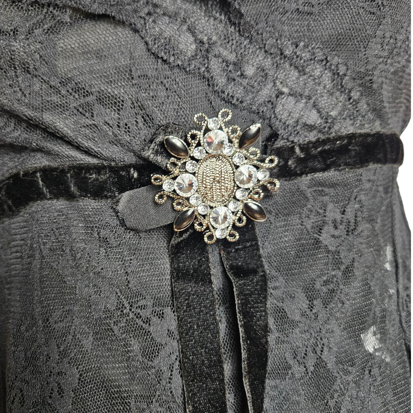 Haut asymétrique noir en dentelle avec broche