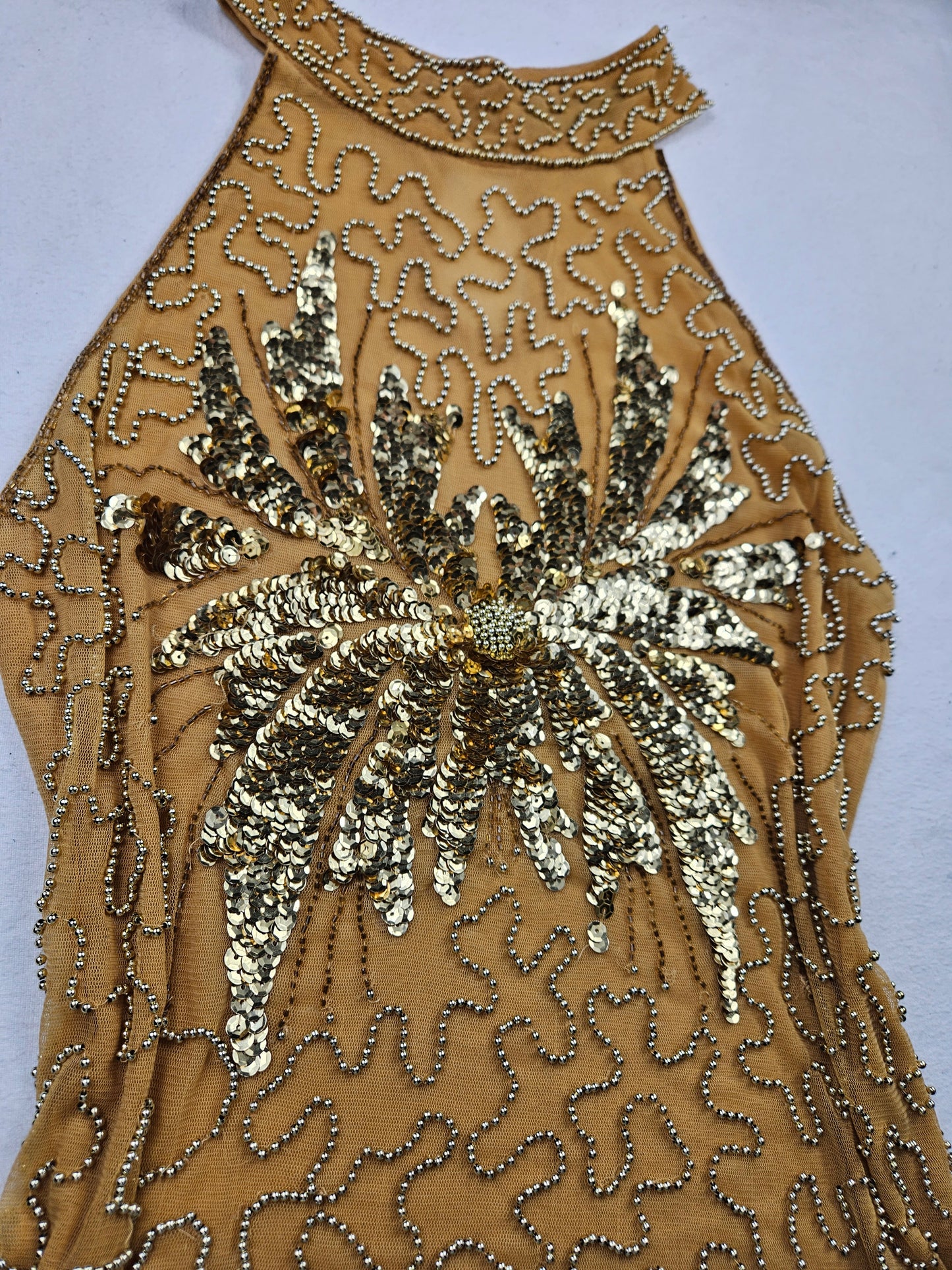 High-necked garment with gold sequins