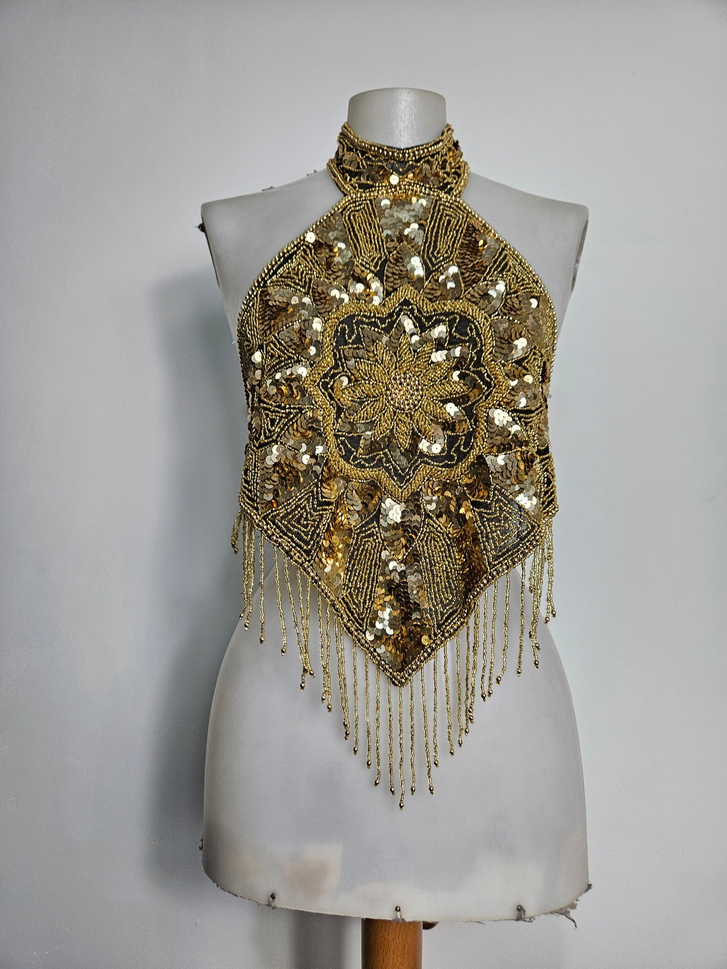 Espalda abierta bordada con lentejuelas doradas.
