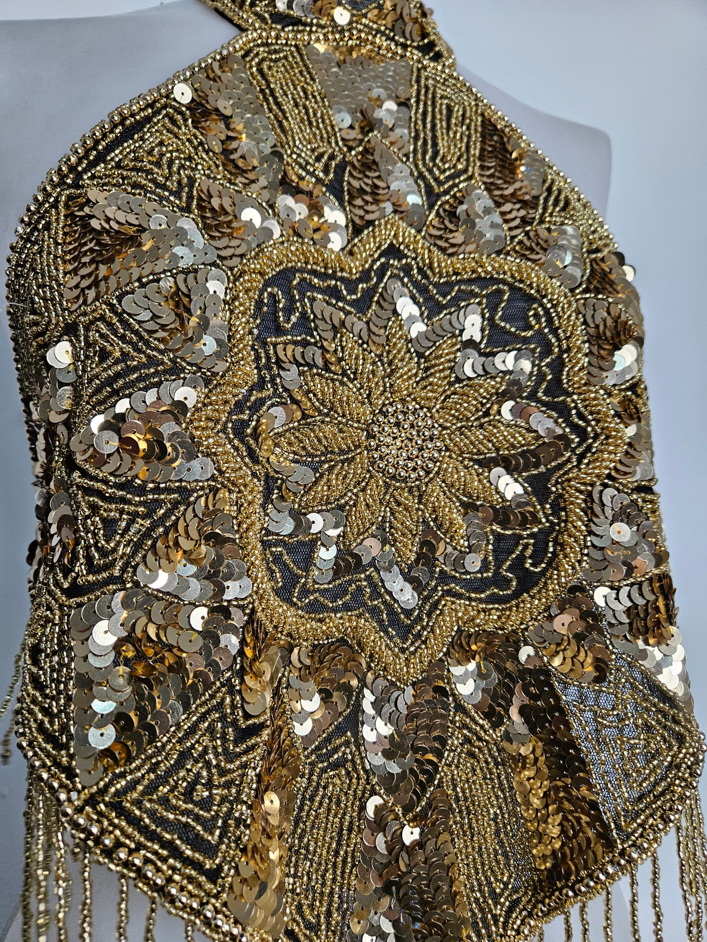 Espalda abierta bordada con lentejuelas doradas.