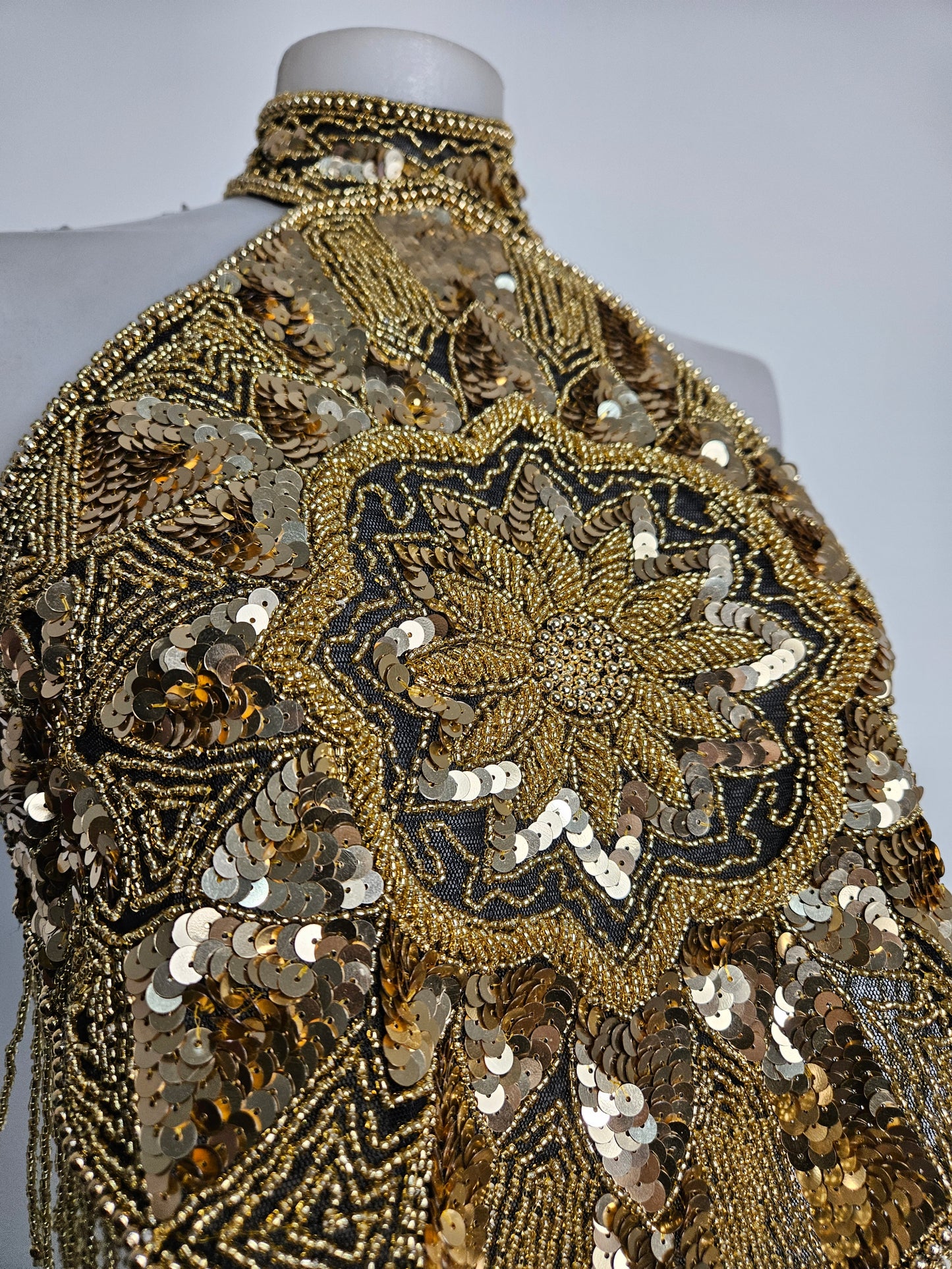 Espalda abierta bordada con lentejuelas doradas.