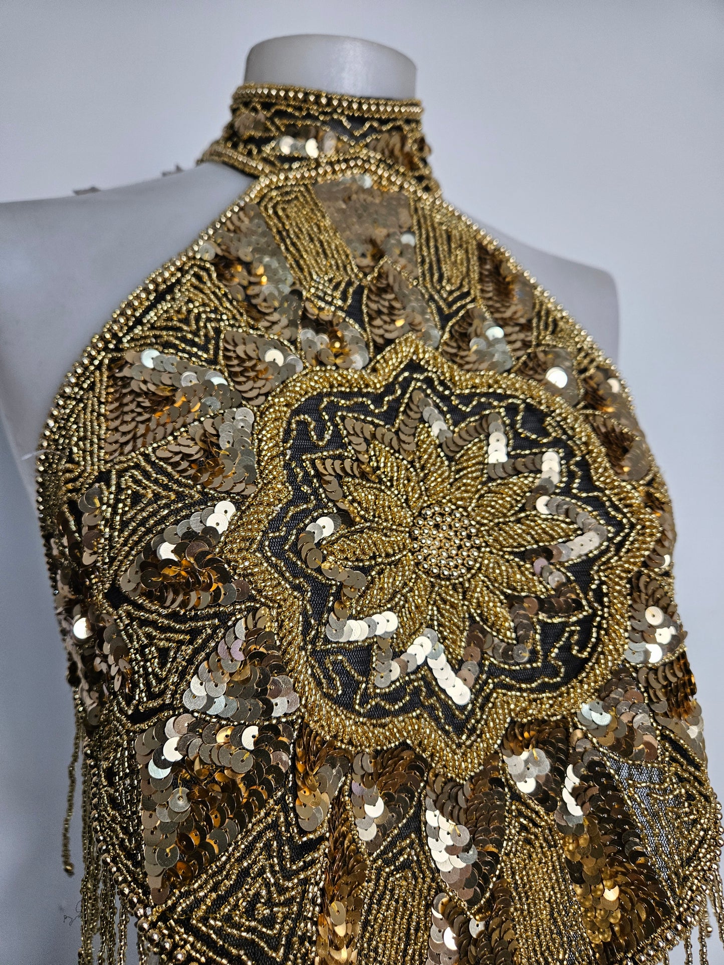 Espalda abierta bordada con lentejuelas doradas.
