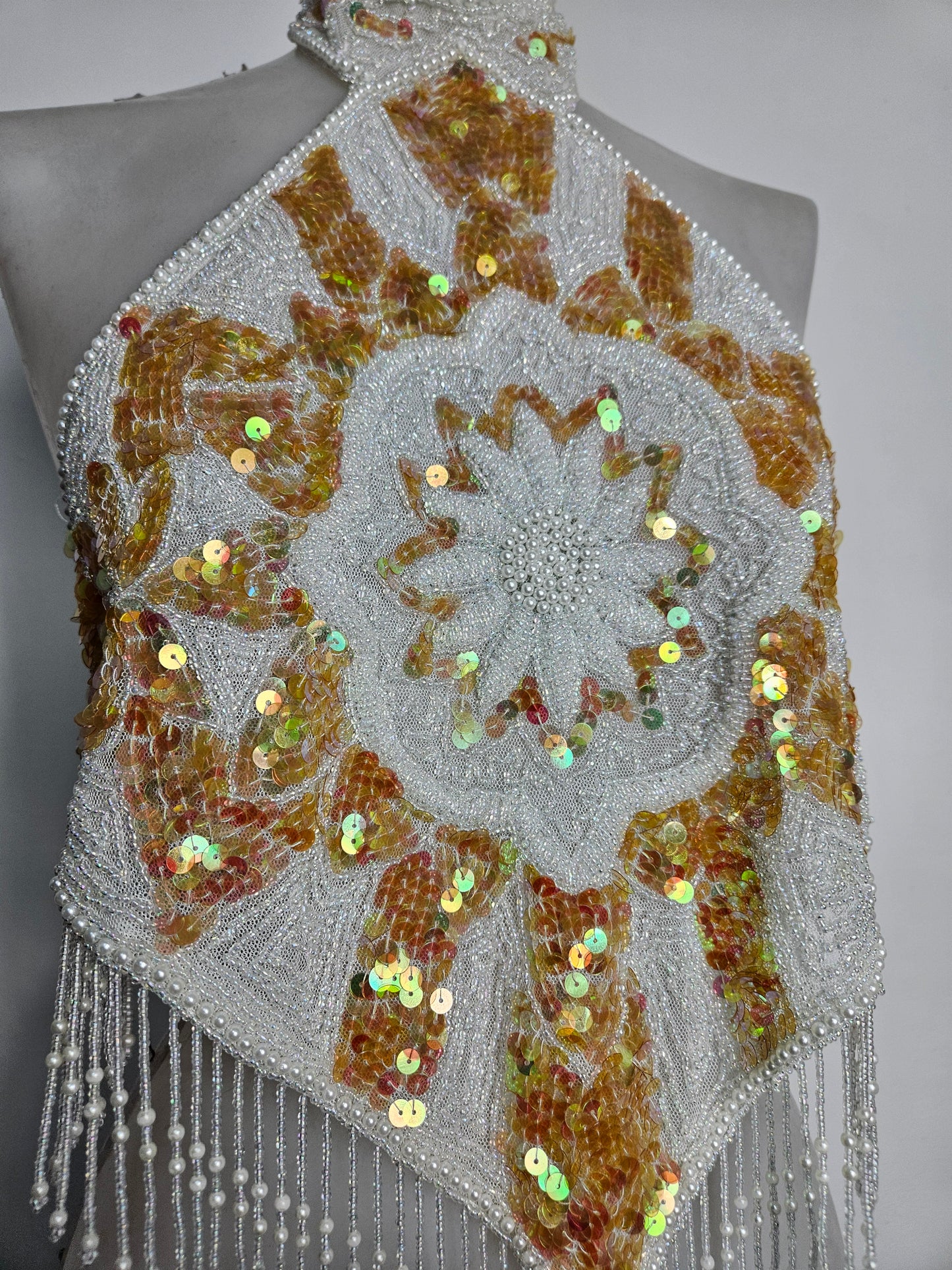 Espalda abierta bordada en blanco y dorado.