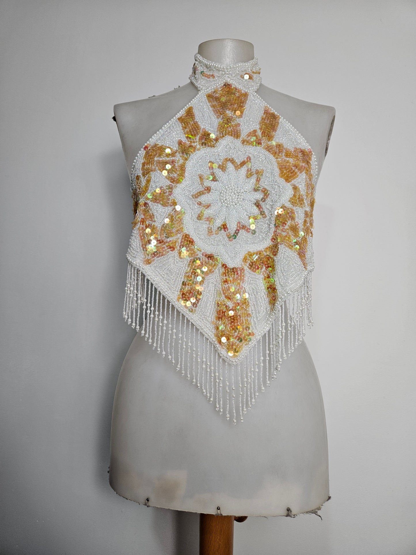 Espalda abierta bordada en blanco y dorado.