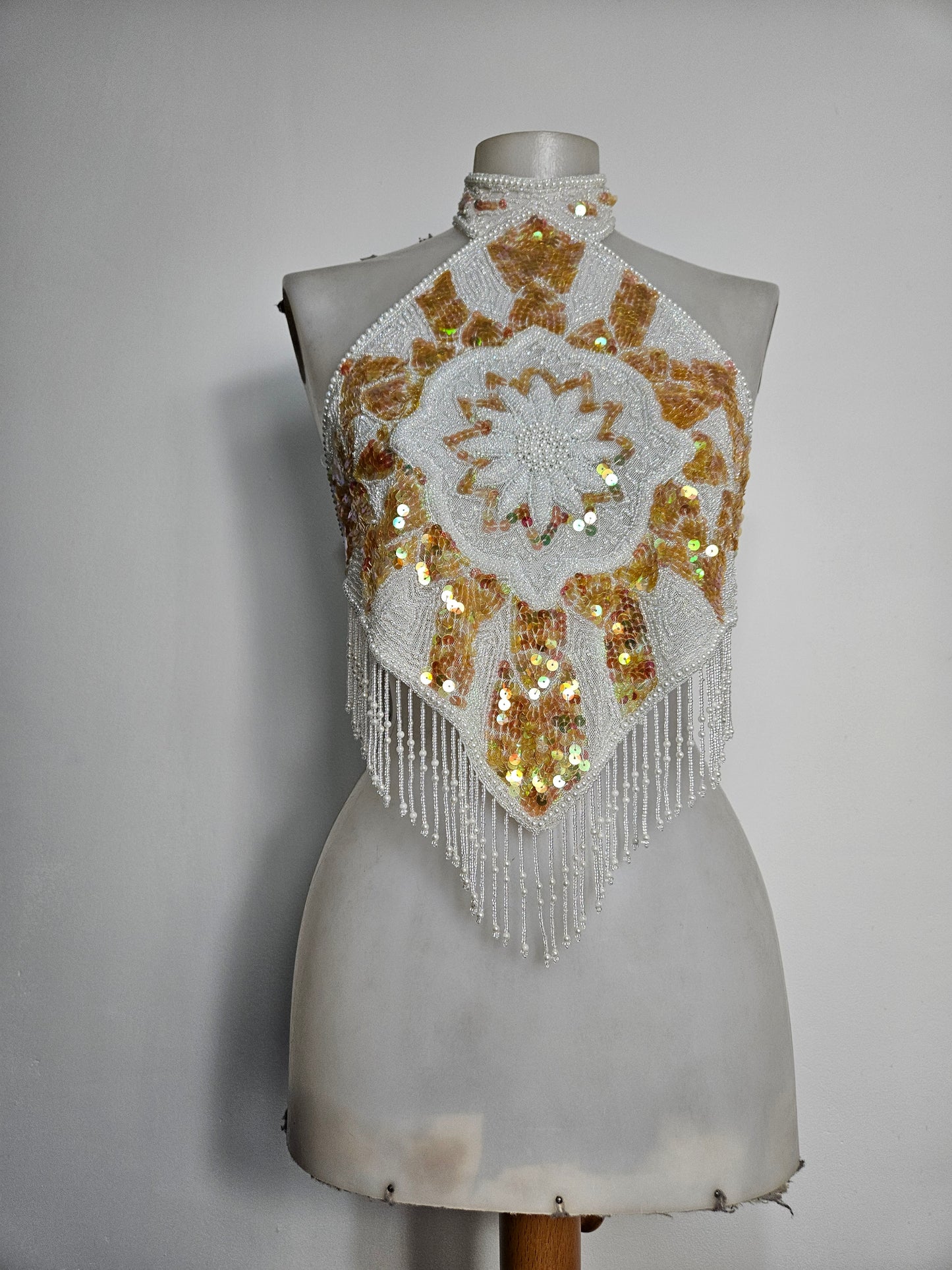 Espalda abierta bordada en blanco y dorado.