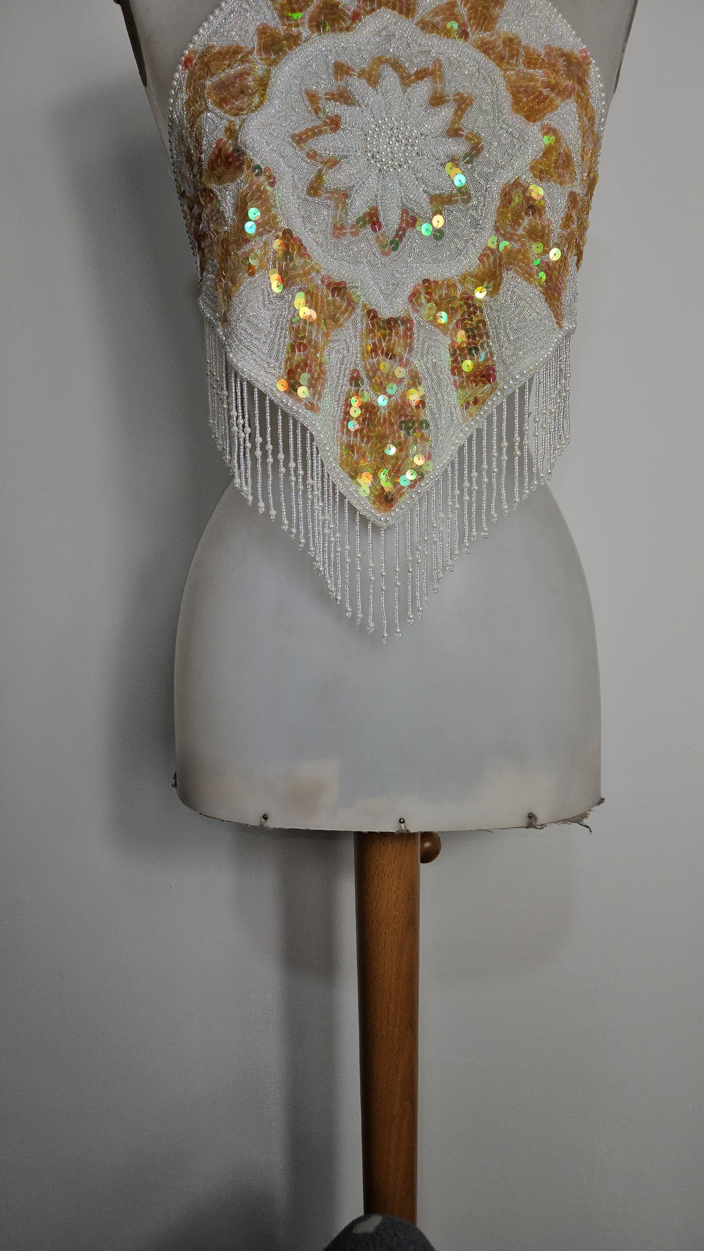 Espalda abierta bordada en blanco y dorado.