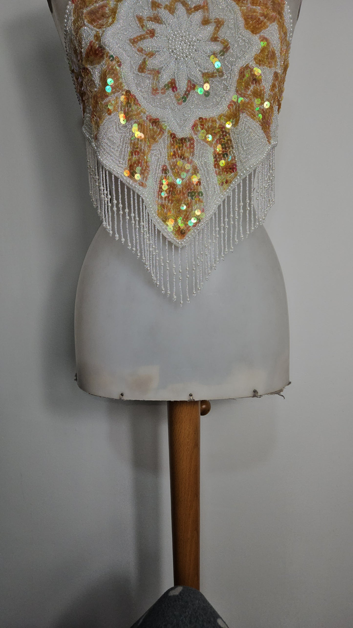 Espalda abierta bordada en blanco y dorado.