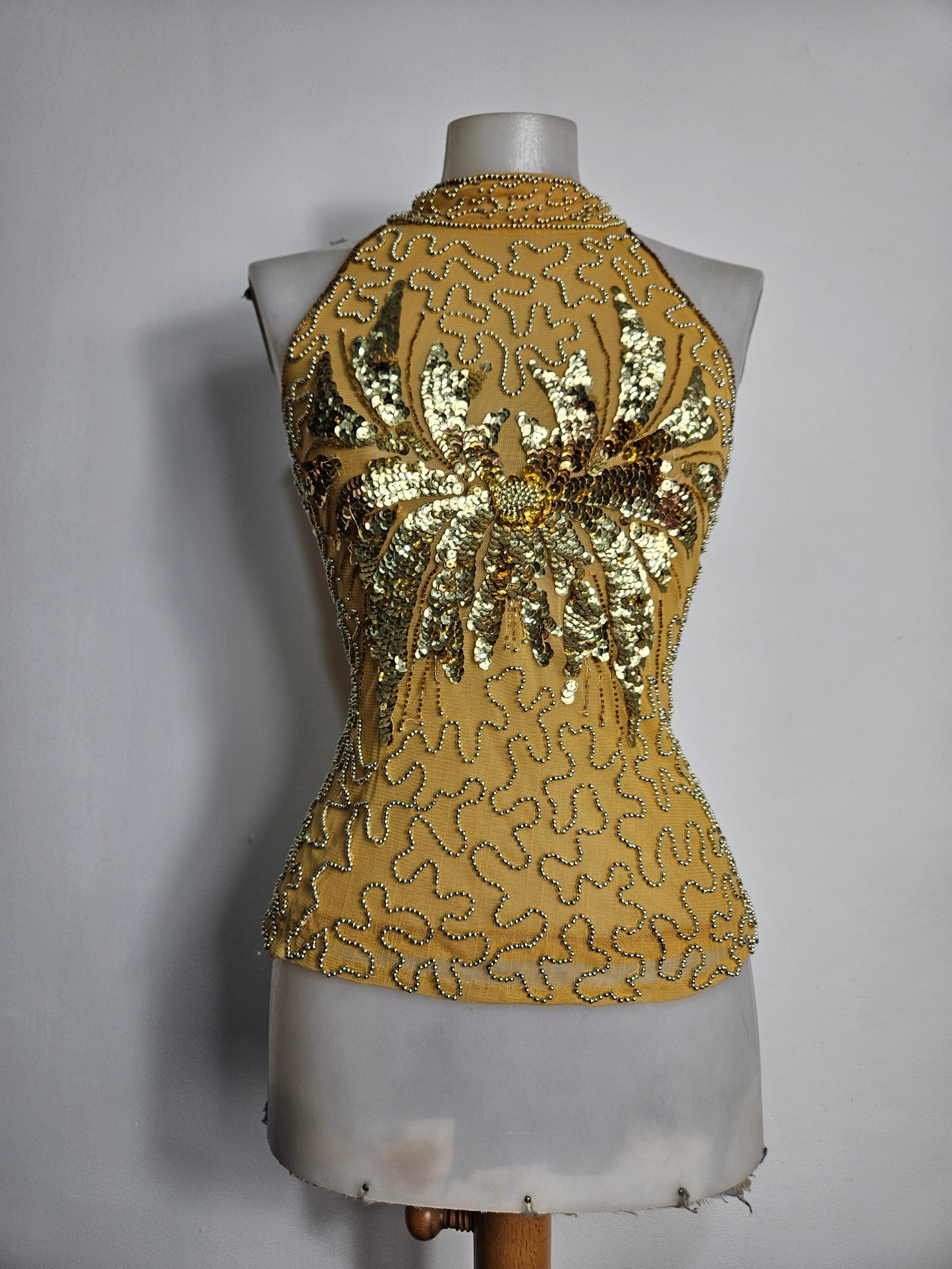 High-necked garment with gold sequins