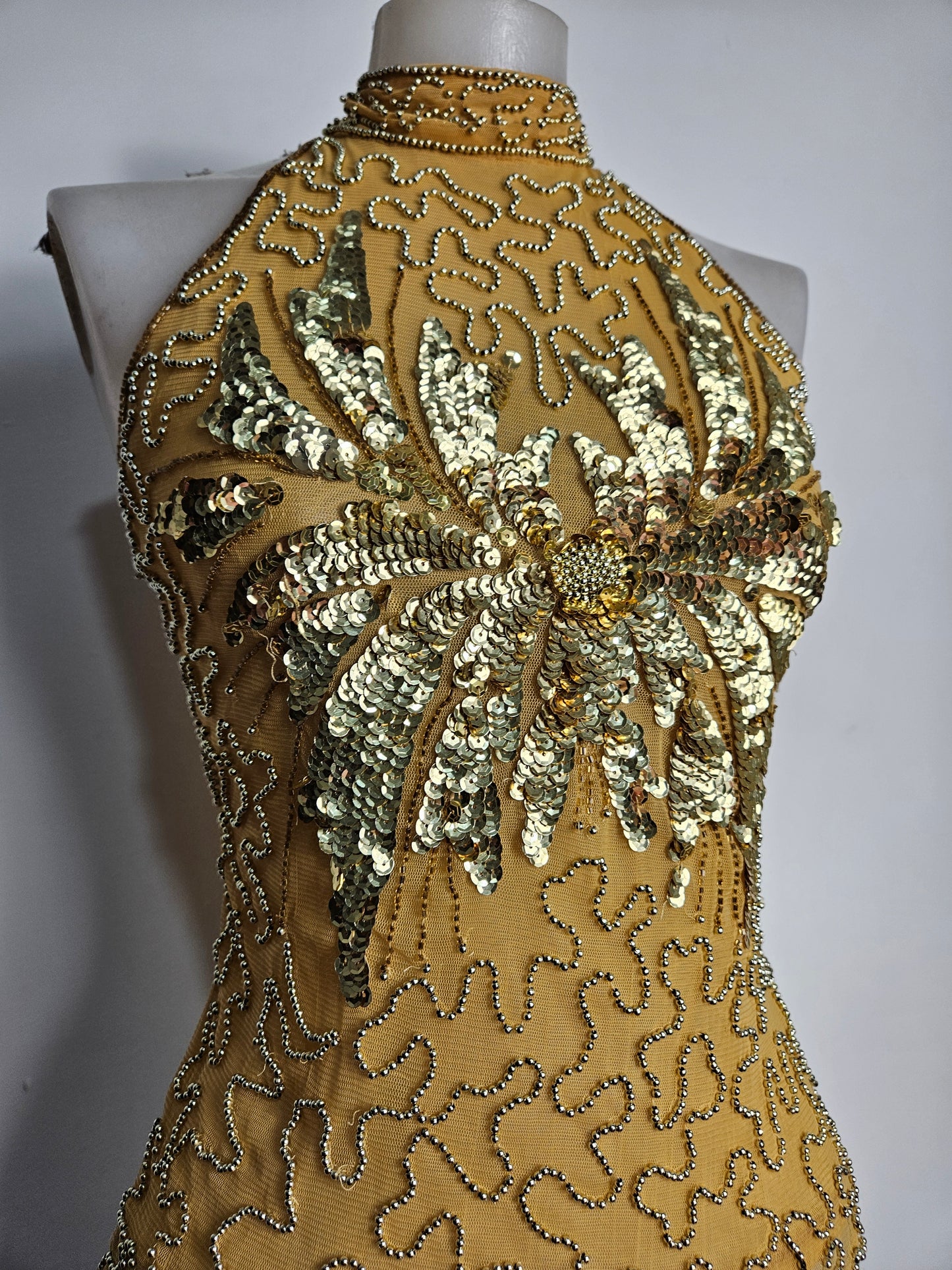 High-necked garment with gold sequins