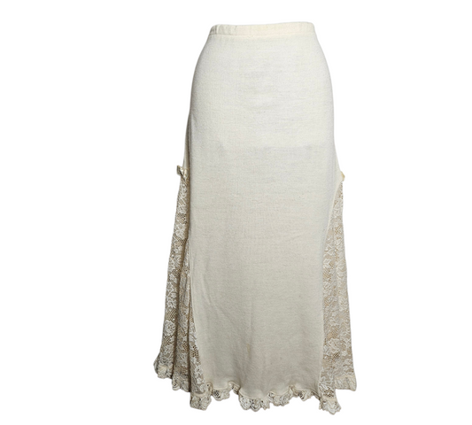 Dreamy fairycore aesthetic long cream knit skirt featuring sheer floral lace side panels, a delicate ribbon bow detail, and a romantic ruffled lace hem for a vintage reverie look.