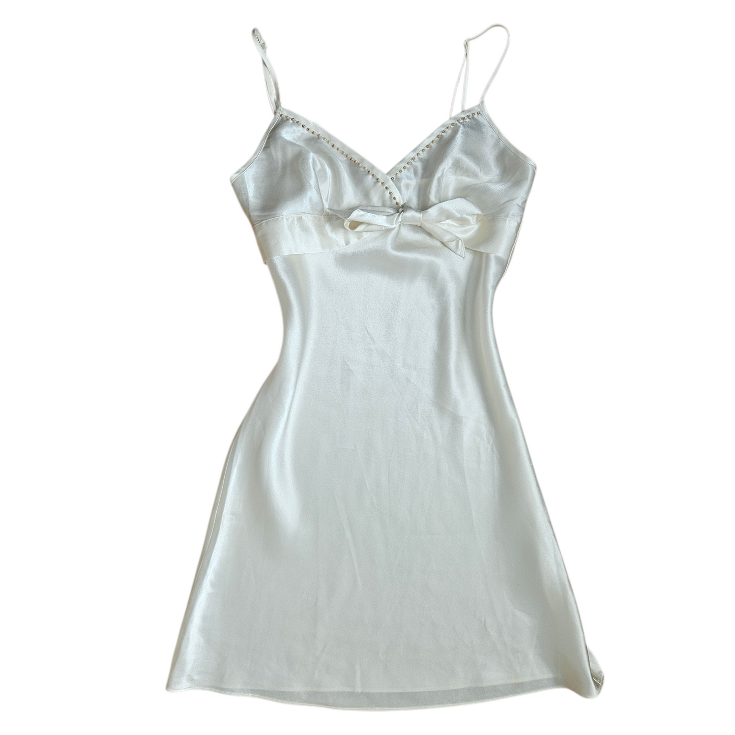 Ivory satin slip dress with delicate straps, V-neckline and underbust bow detail, soft y2k romantic vintage aesthetic.