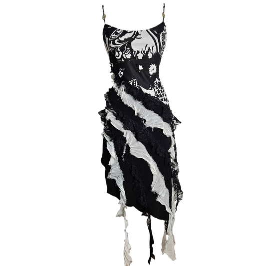 Black and white layered dress with lace ruffles and distressed finishes, fairycore whimsigoth aesthetic, dramatic texture and early 2000s gothic vibe.