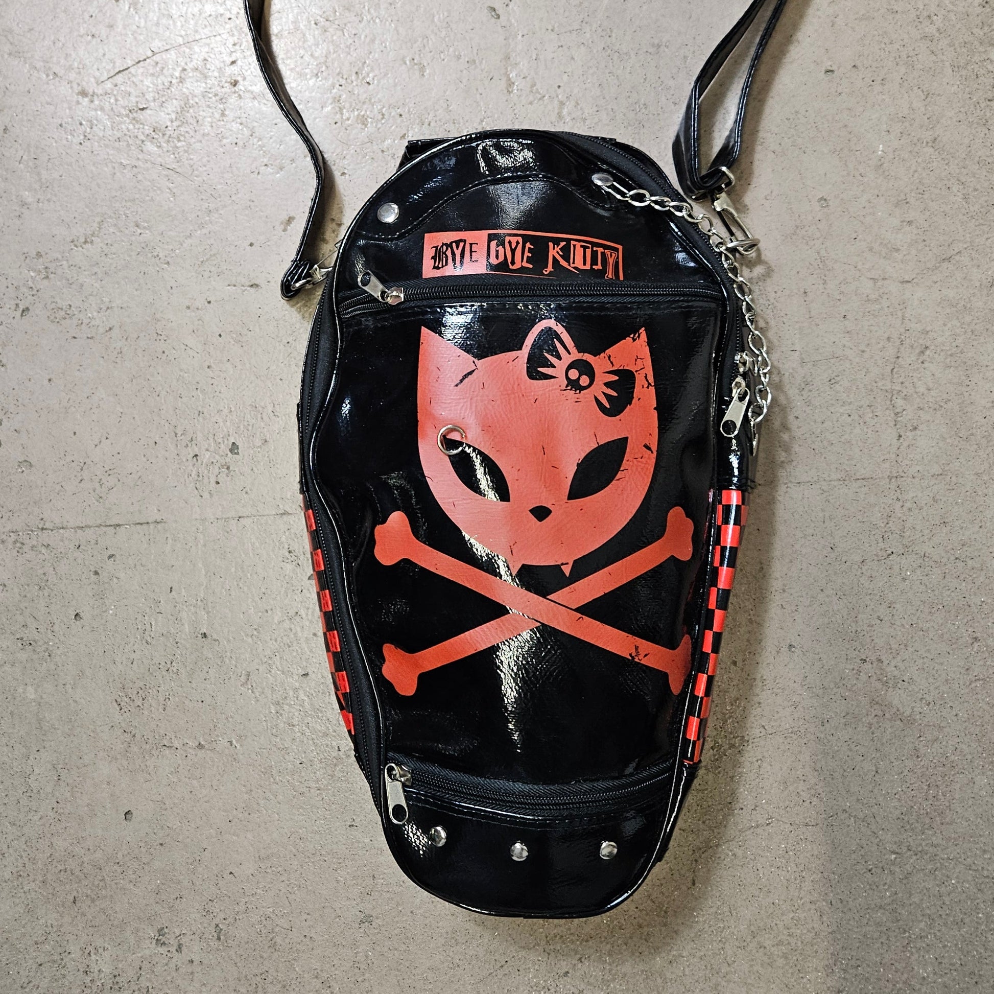 Vintage coffin shaped handbag with kitty skull graphic, glossy black Y2K goth punk aesthetic crossbody bag by Lucid Dream 2007.