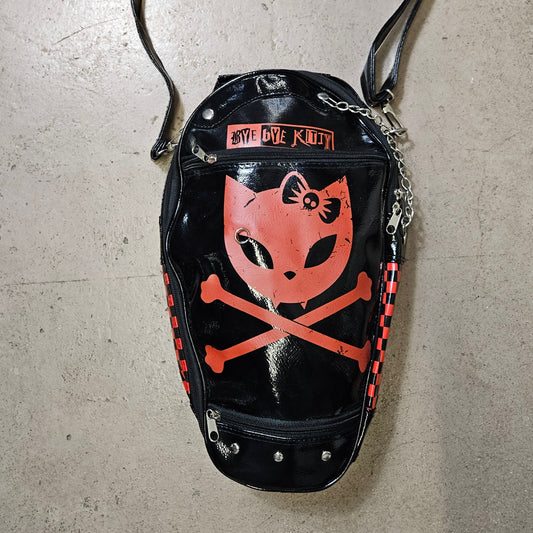 Vintage coffin shaped handbag with kitty skull graphic, glossy black Y2K goth punk aesthetic crossbody bag by Lucid Dream 2007.