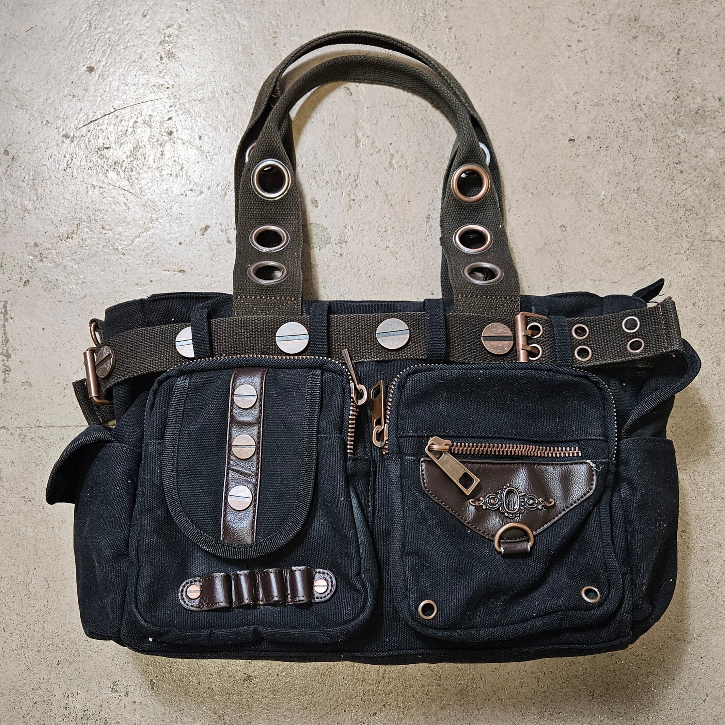 Vintage black utility handbag with cargo pockets and metal hardware, edgy Y2K grunge cybercore aesthetic statement bag by Lucid Dream 2007.