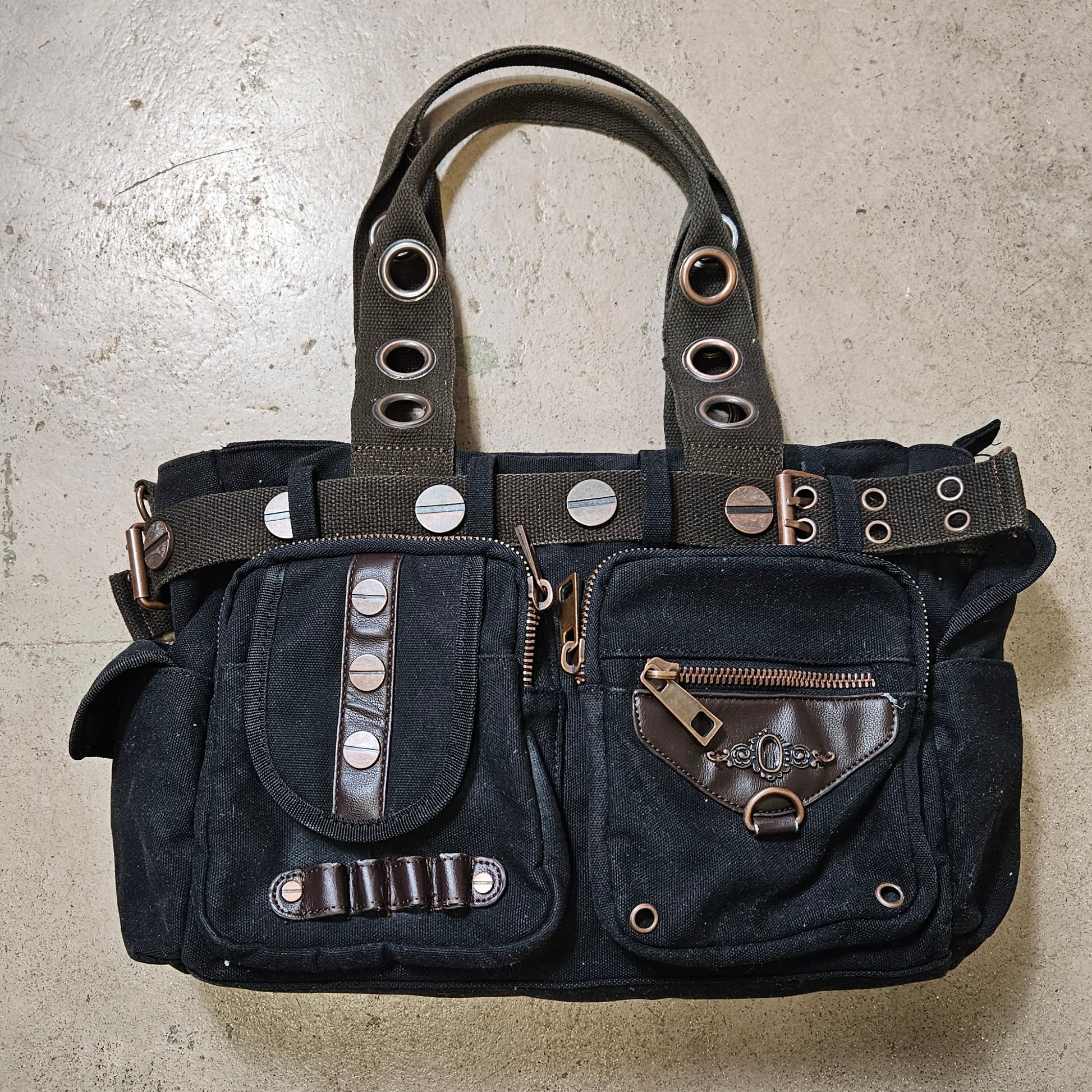 Vintage black utility handbag with cargo pockets and metal hardware, edgy Y2K grunge cybercore aesthetic statement bag by Lucid Dream 2007.