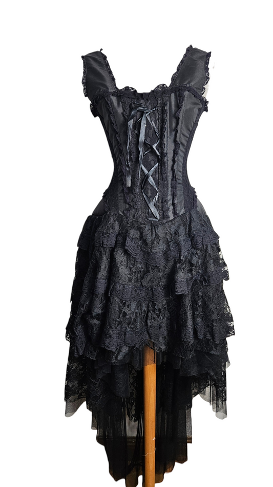 Black gothic Victorian-style dress with a corset bodice, lace-up detail, and tiered ruffled lace high-low skirt on a mannequin.