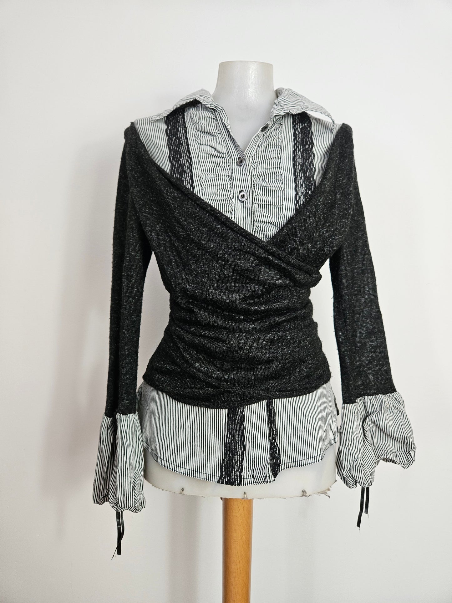 Y2K layered top featuring a striped button-down shirt with black lace trim and an attached grey wrap-style cardigan overlay.