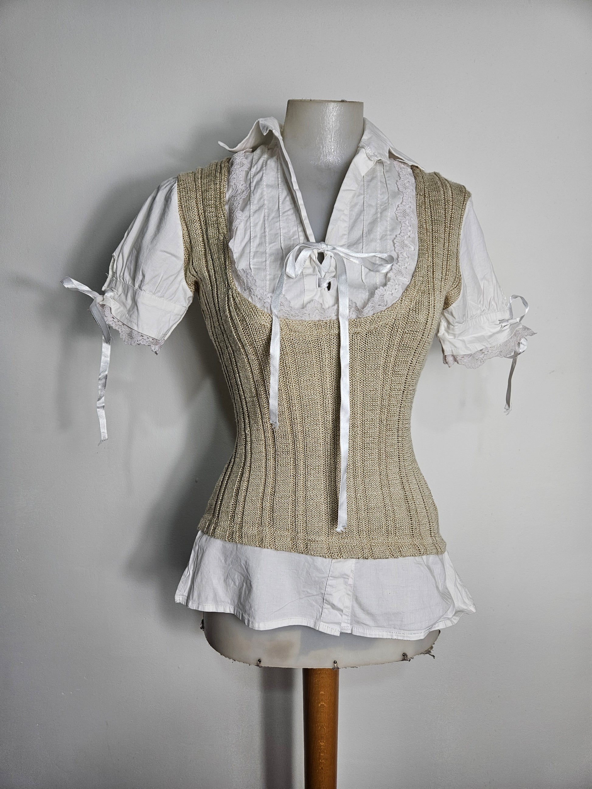 Vintage Zone Bleue milkmaid style top, beige ribbed knit vest layered over a white lace-trimmed puff sleeve blouse with ribbon ties.
