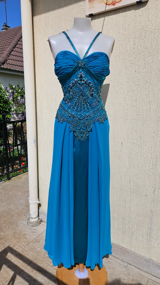 Turquoise blue chiffon evening gown with halter neck, pleated bust, and ornate teal bead & crystal bodice embroidery. Elegant mermaid style formal dress.