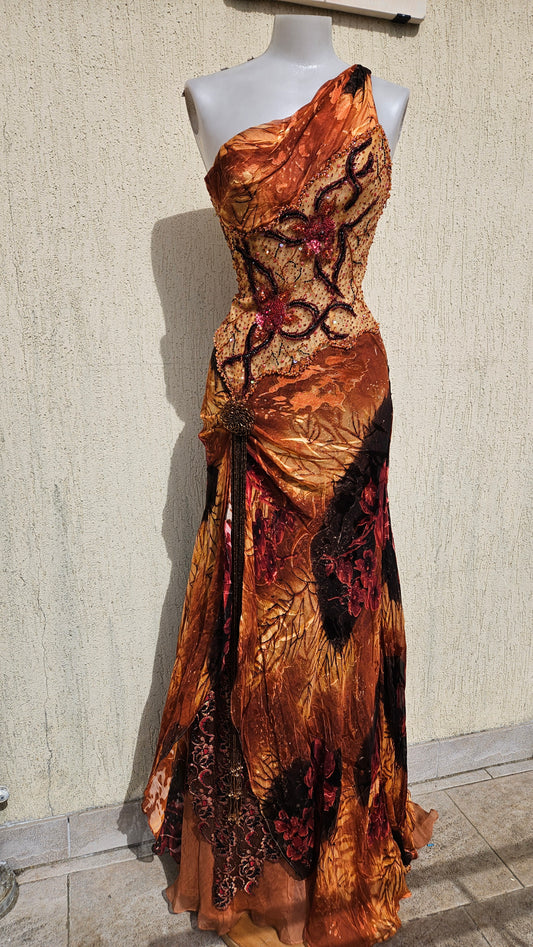 Vintage Y2K orange one-shoulder maxi dress on a mannequin. Intricate beaded bodice, layered mixed-print skirt, and side tassel. Art-to-wear evening gown.
