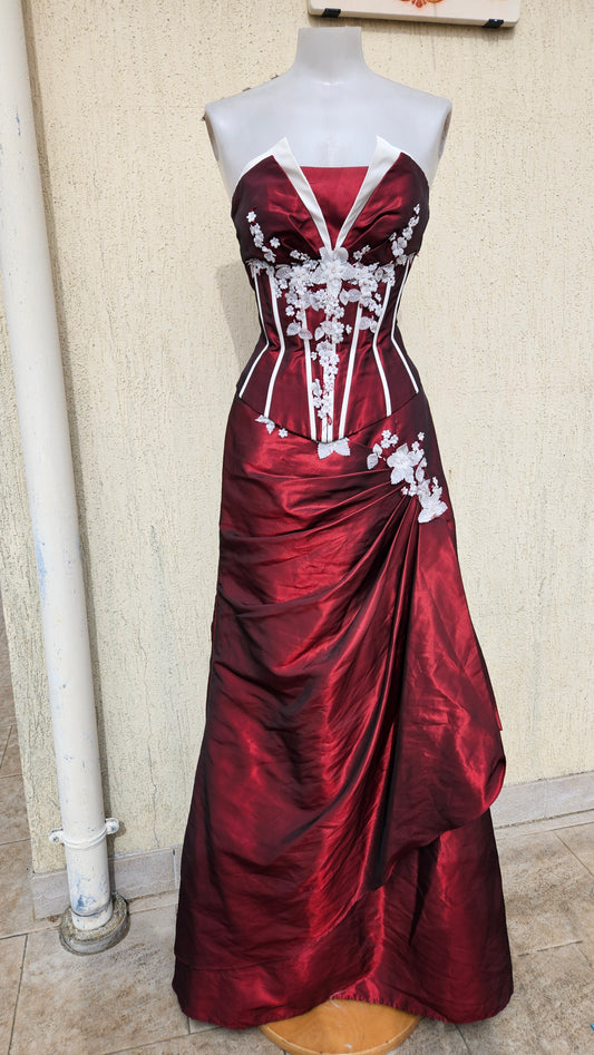 Striking strapless crimson and white corset gown with floral embroidery on a mannequin.