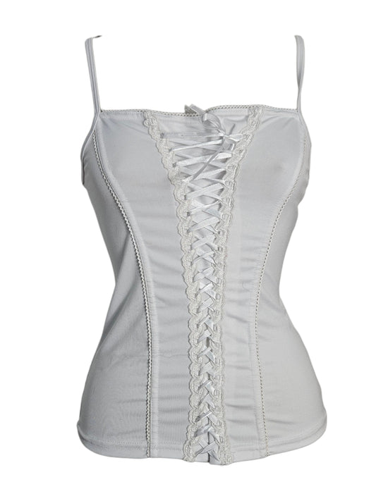 Haut blanc à fines bretelles, conçu avec une structure proche d'un corset.

Le devant présente un laçage central blanc bordé d'une bande de dentelle. top vintage dans le style fairycore, sorti d'une reverie.