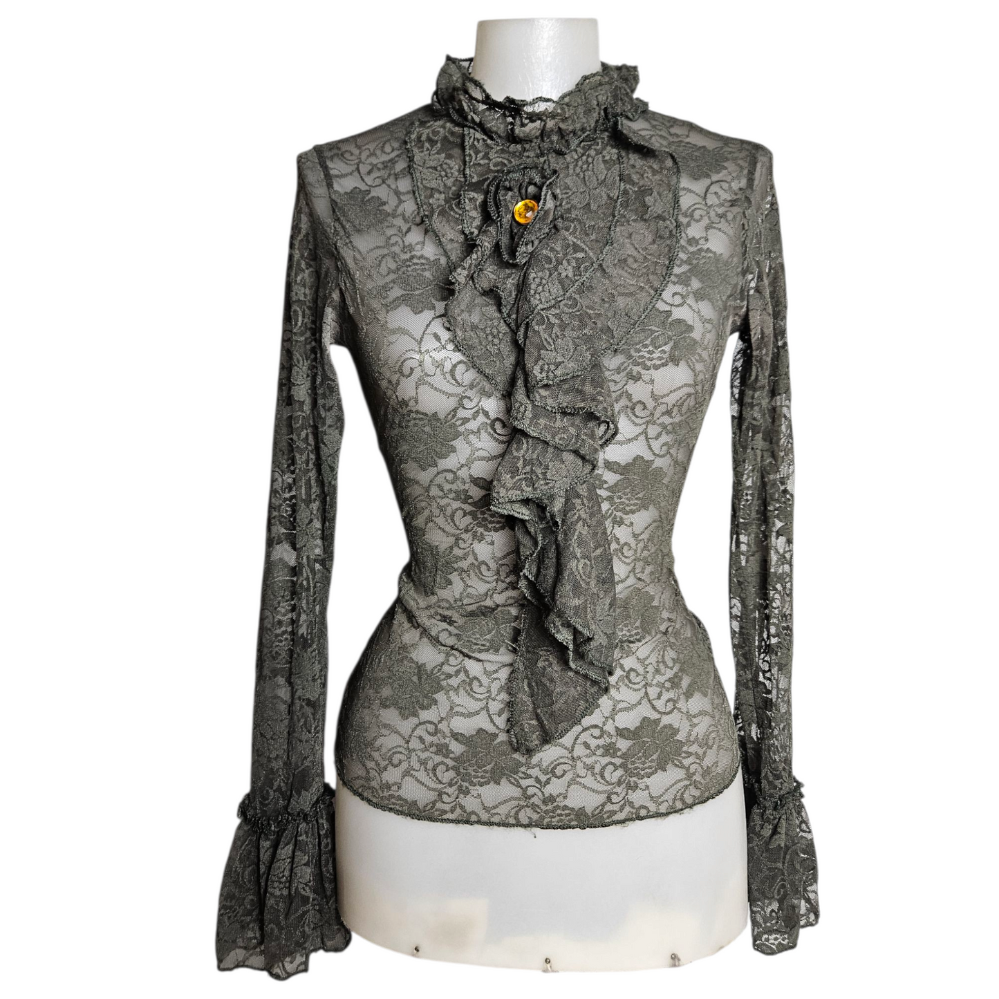 Lace blouse with ruffle details and brooch