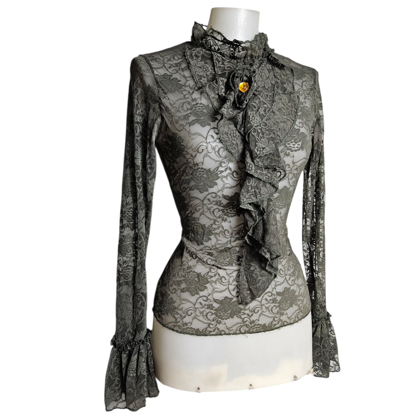 Lace blouse with ruffle details and brooch