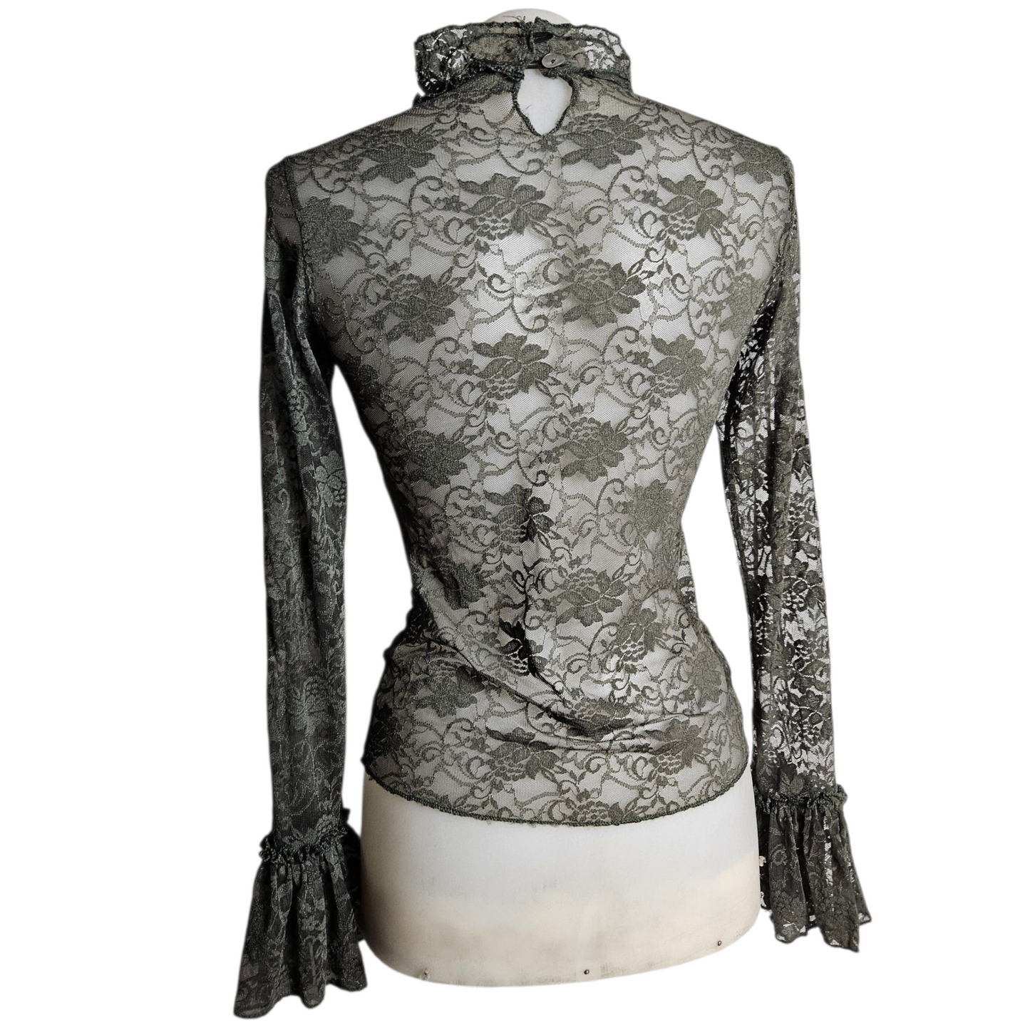 Lace blouse with ruffle details and brooch