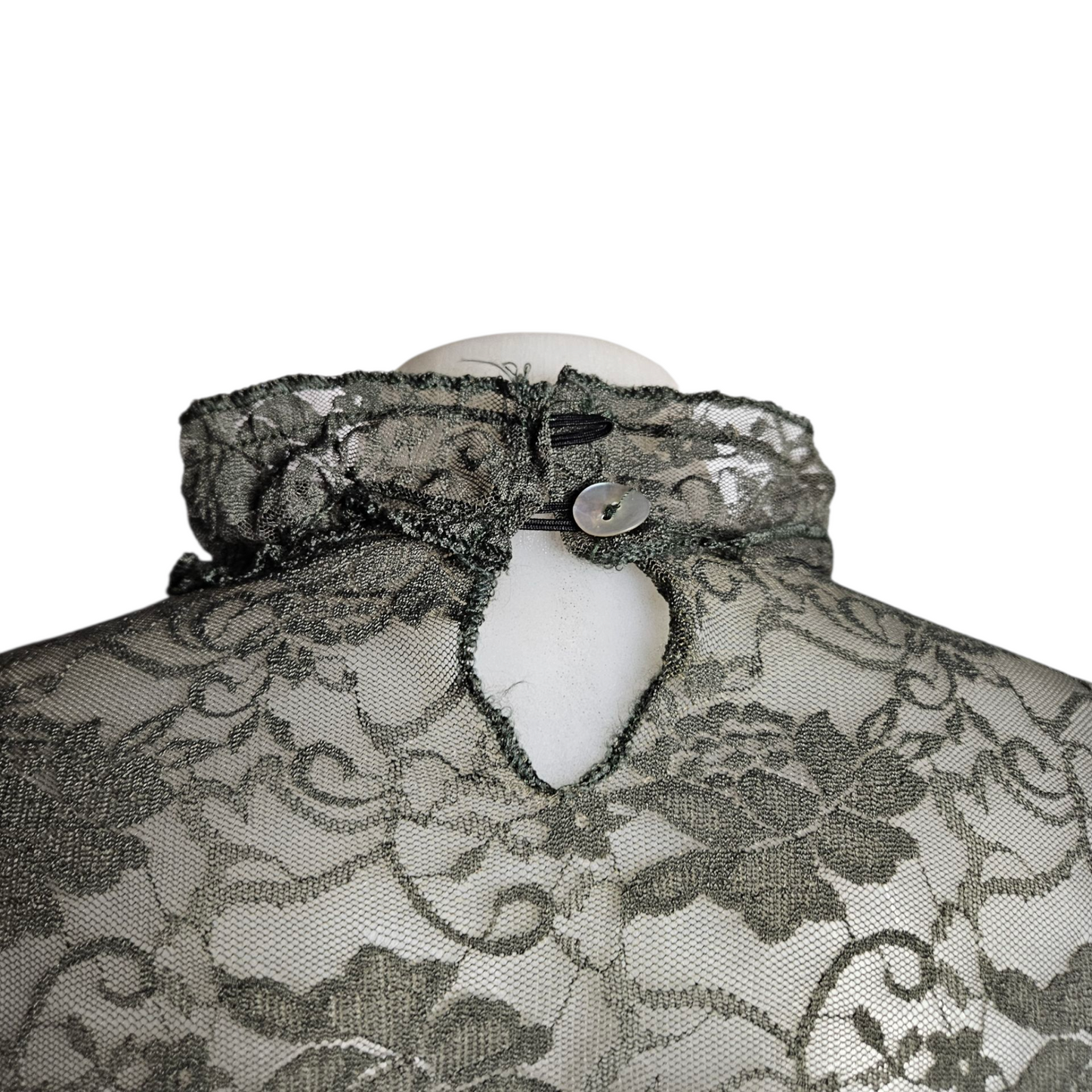 Lace blouse with ruffle details and brooch