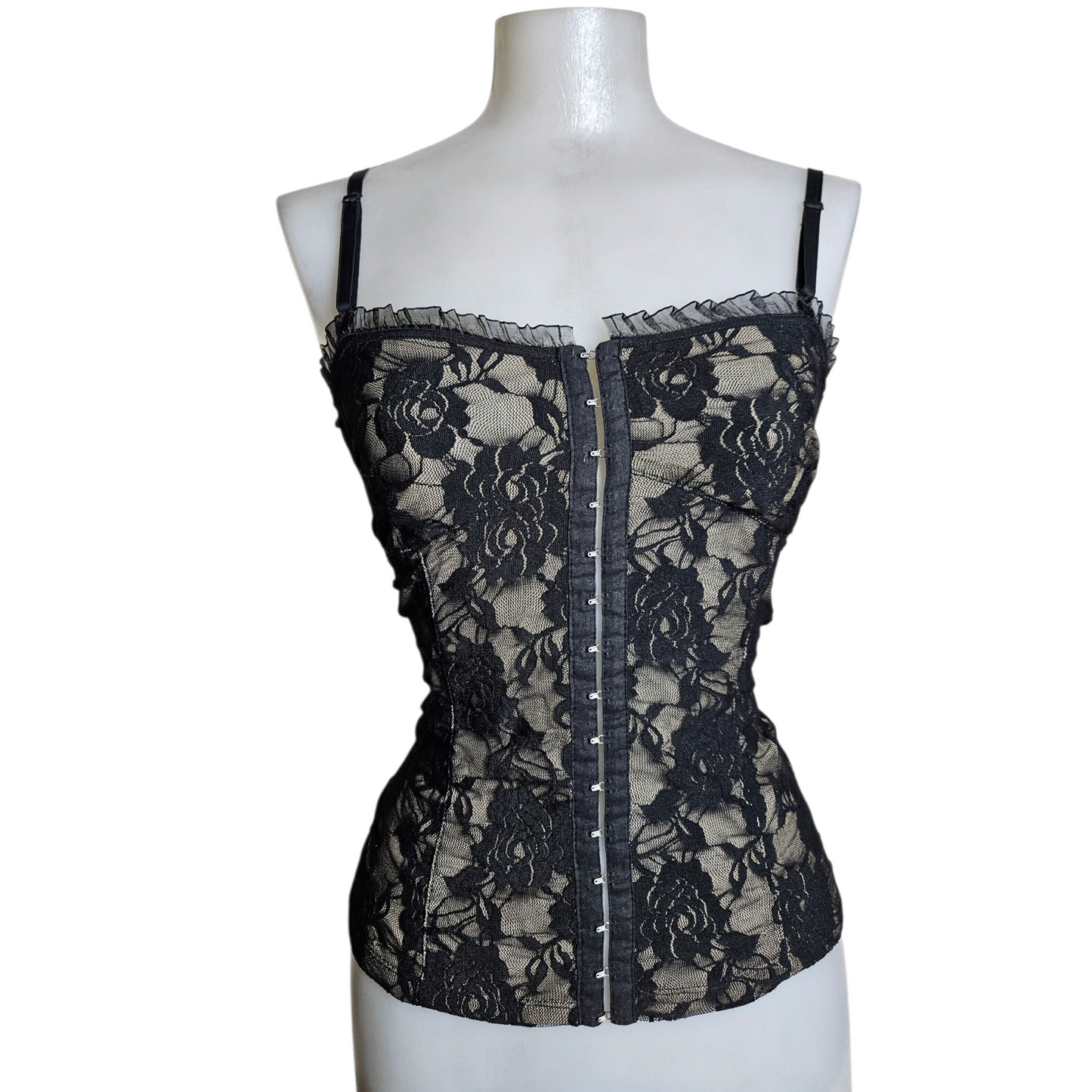 Black lace corset top on a beige background