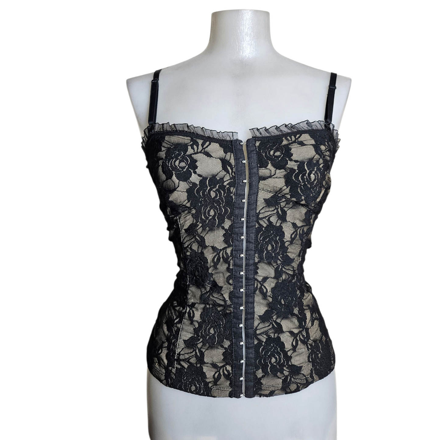 Black lace corset top on a beige background