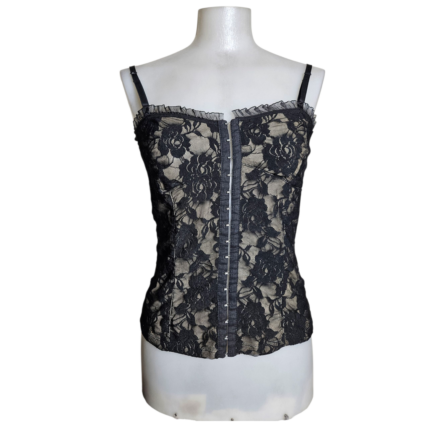 Black lace corset top on a beige background