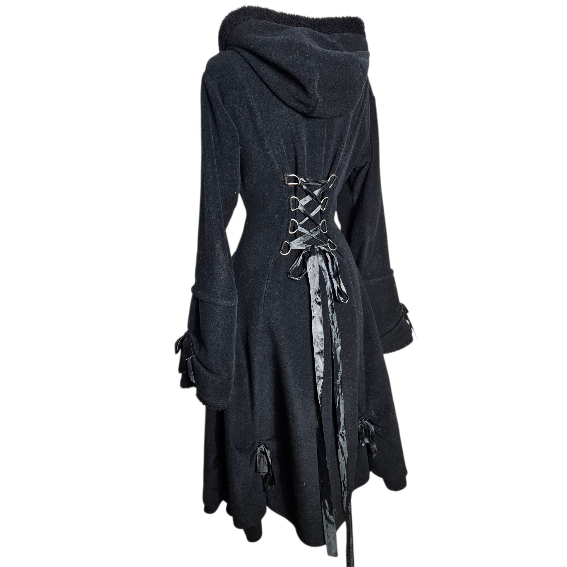 Back view of vintage black hooded dress with lace-up corset detail, photographed on white background