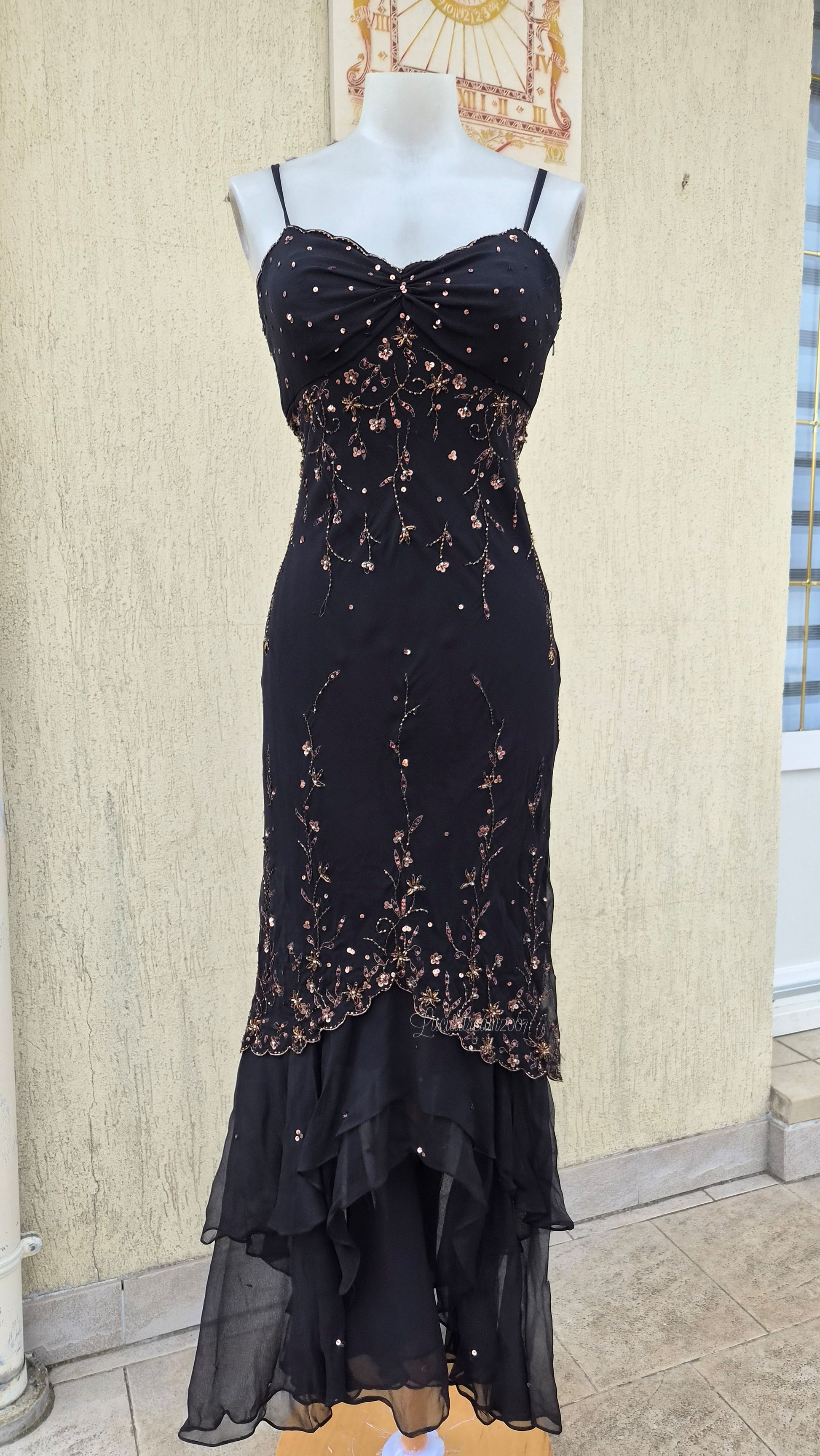 Robe en soie longue noire élégante, style gothique romantique avec broderies perlées et sequins cuivrés. Coupe cintrée, bas volanté en mousseline, idéale pour une tenue de soirée.
