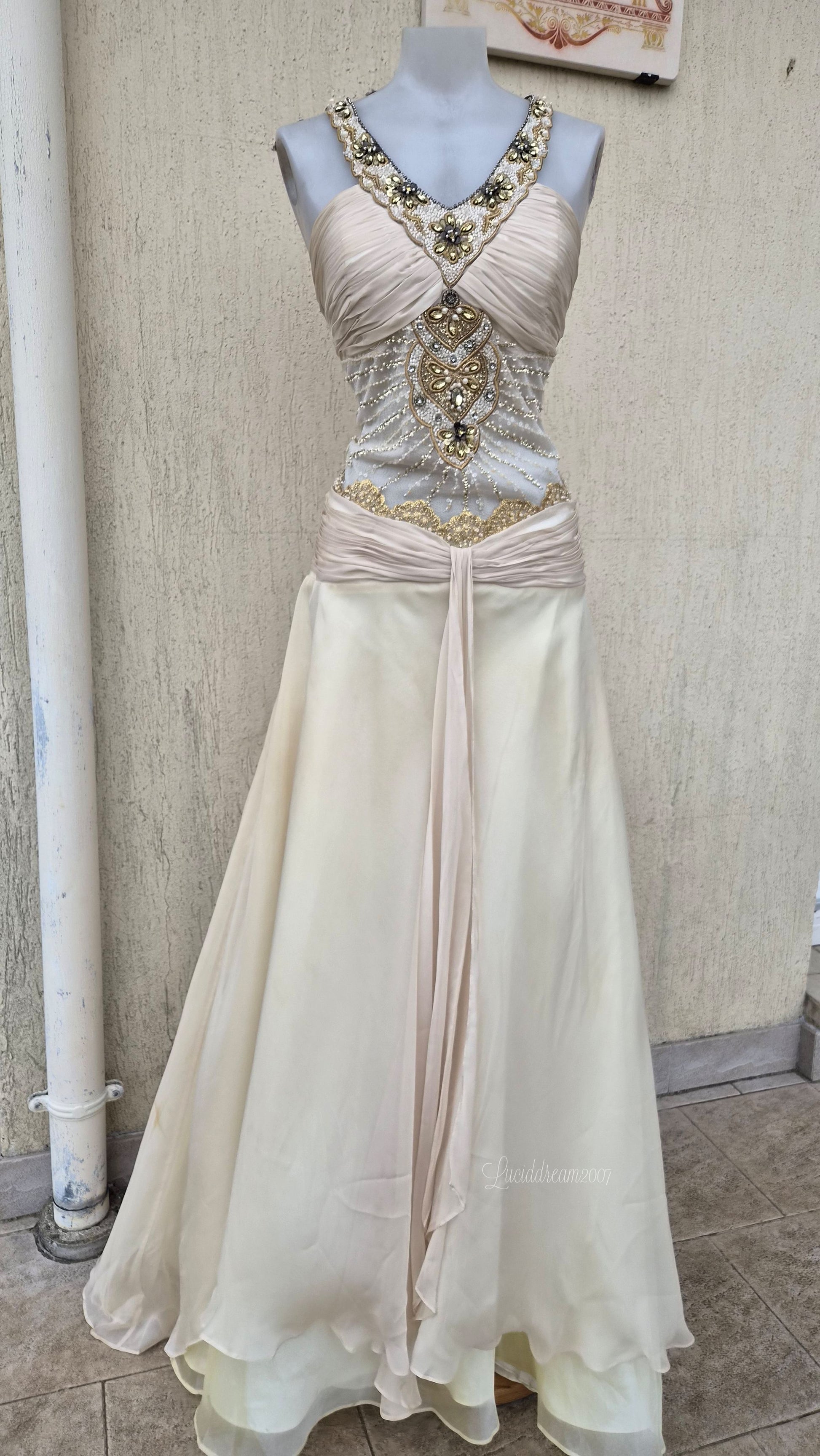 Robe structurée avec un bustier drapé et est richement orné de broderies, de perles et de sequins aux tons dorés et blancs. Style greek goddess sortie d'une reverie fairycore.