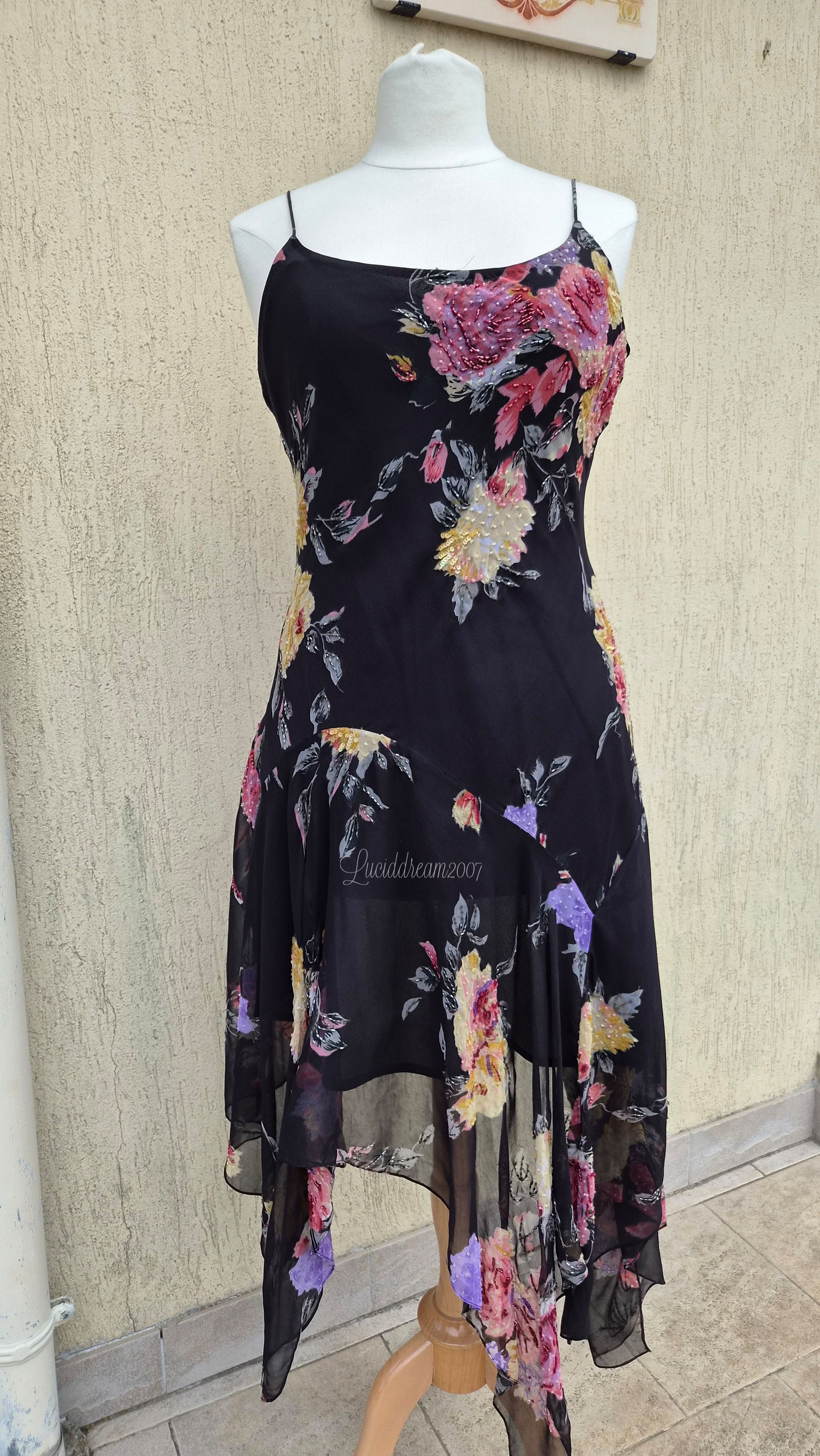 Robe noire à motif floral. Coupe asymétrique avec détails de broderies de perles et sequins. Dans le style René Derhy