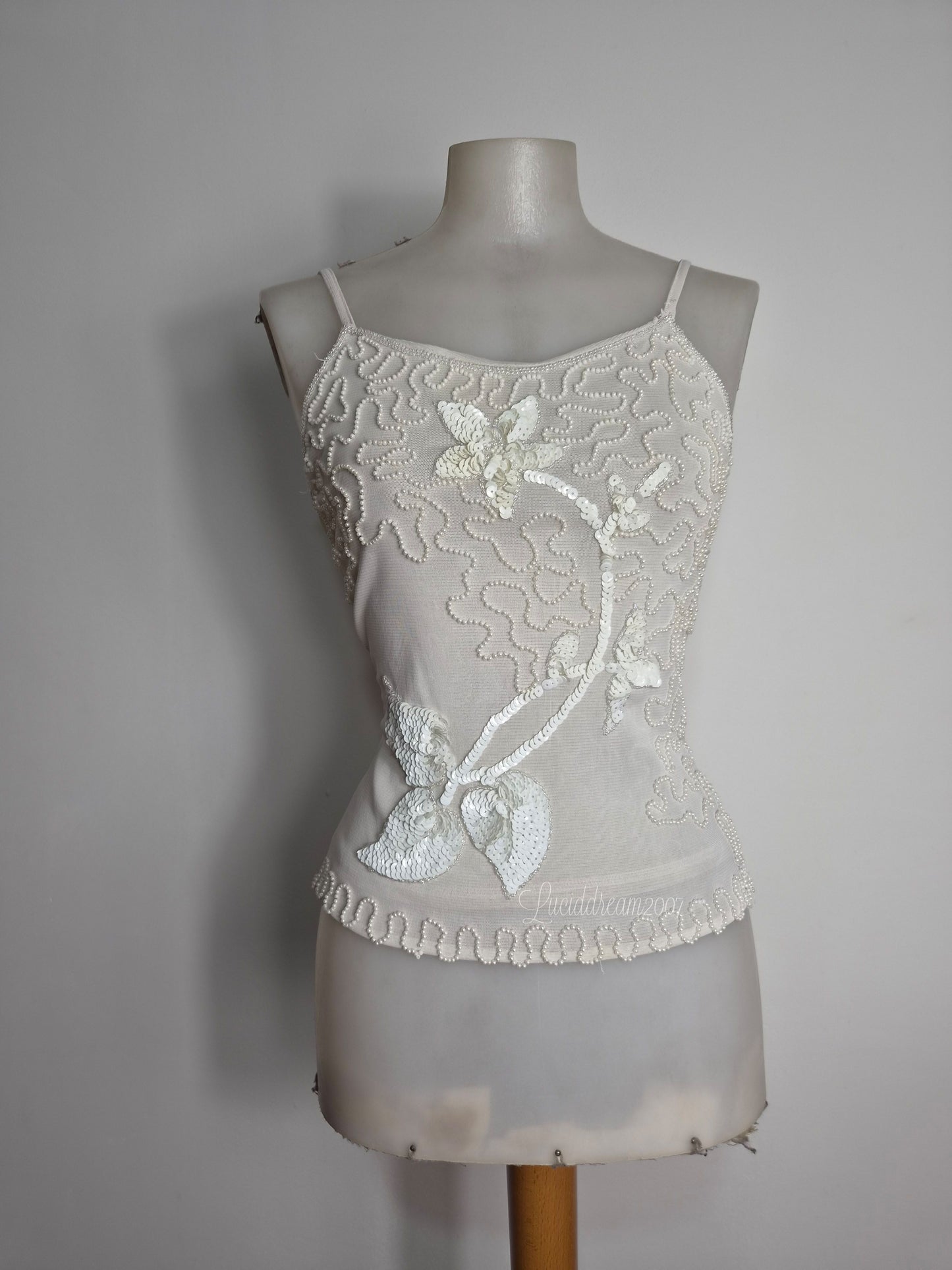 Débardeur vintage Y2K crème avec d'élégantes broderies de perles blanches et des applications de sequins floraux. Esthétique féerique fairycore sortie d'une reverie.