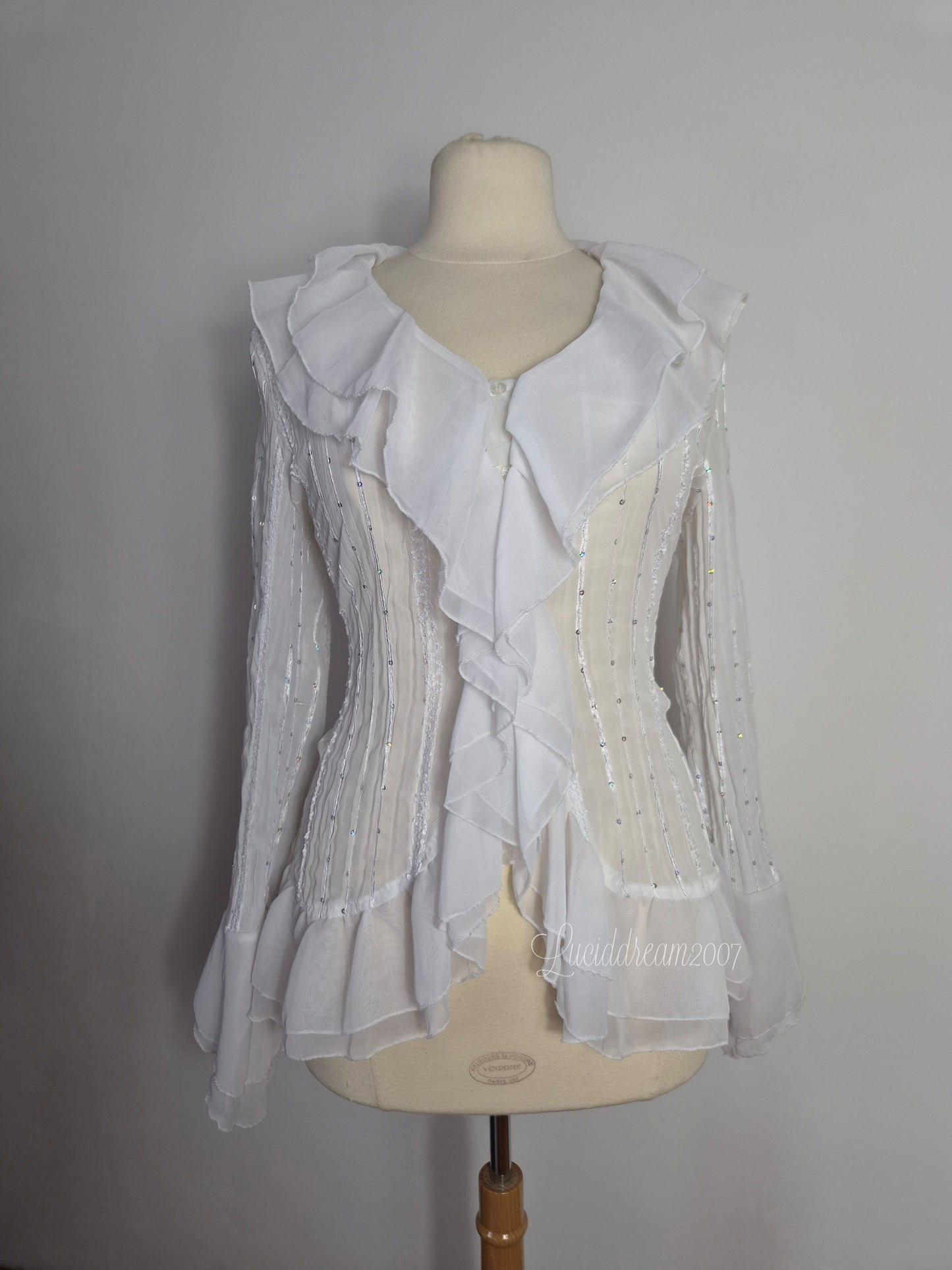 Blusa blanca con volantes y detalles de lentejuelas
