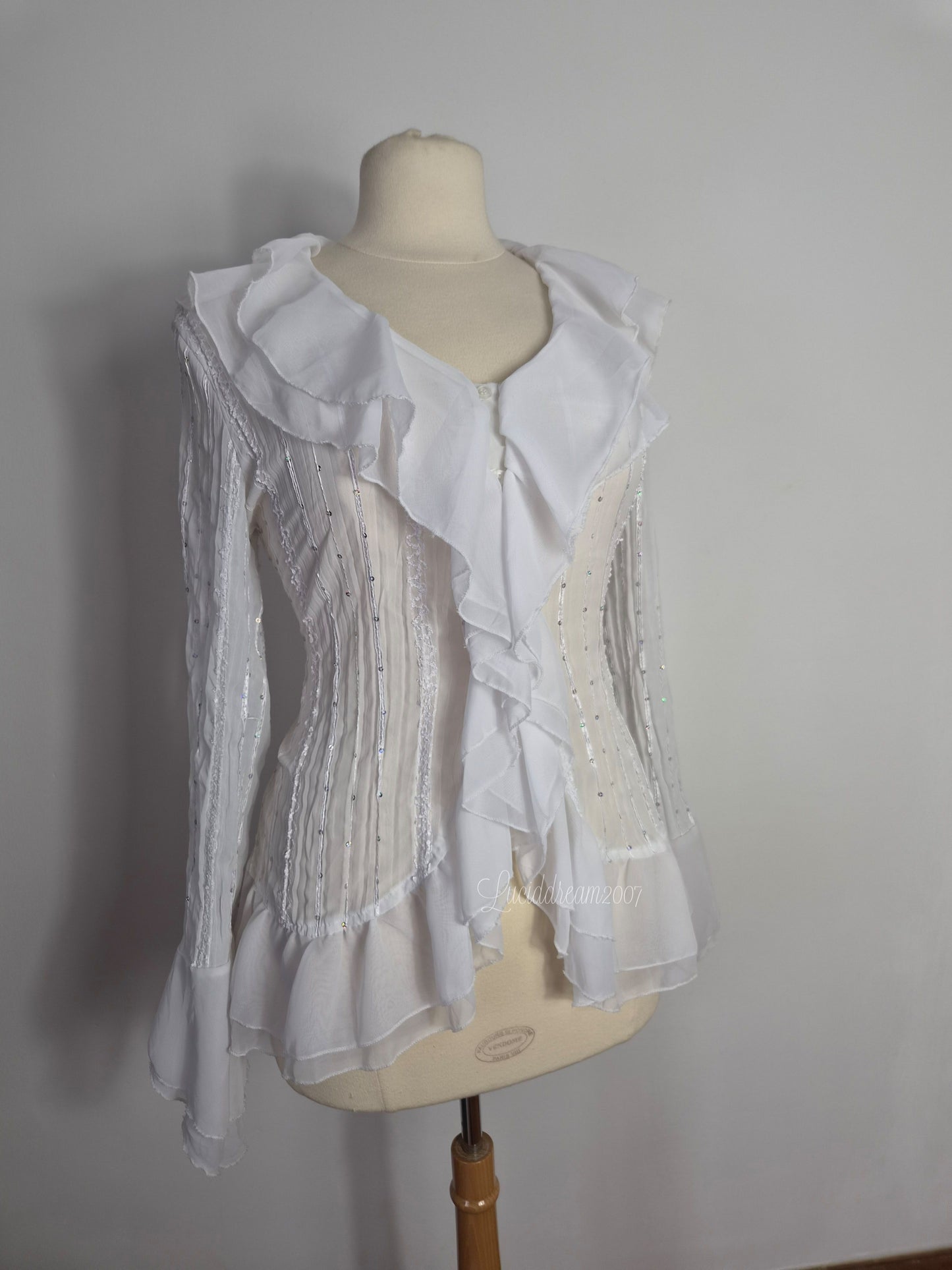 Blusa blanca con volantes y detalles de lentejuelas