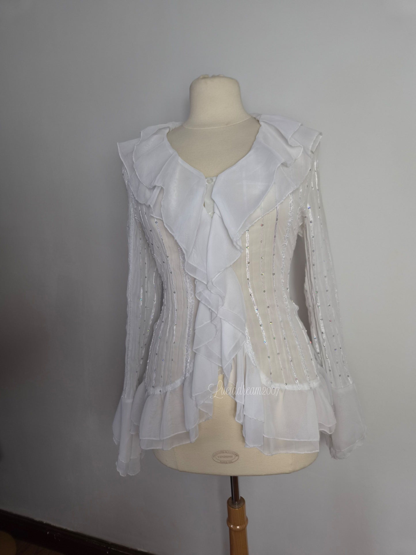 Blusa blanca con volantes y detalles de lentejuelas