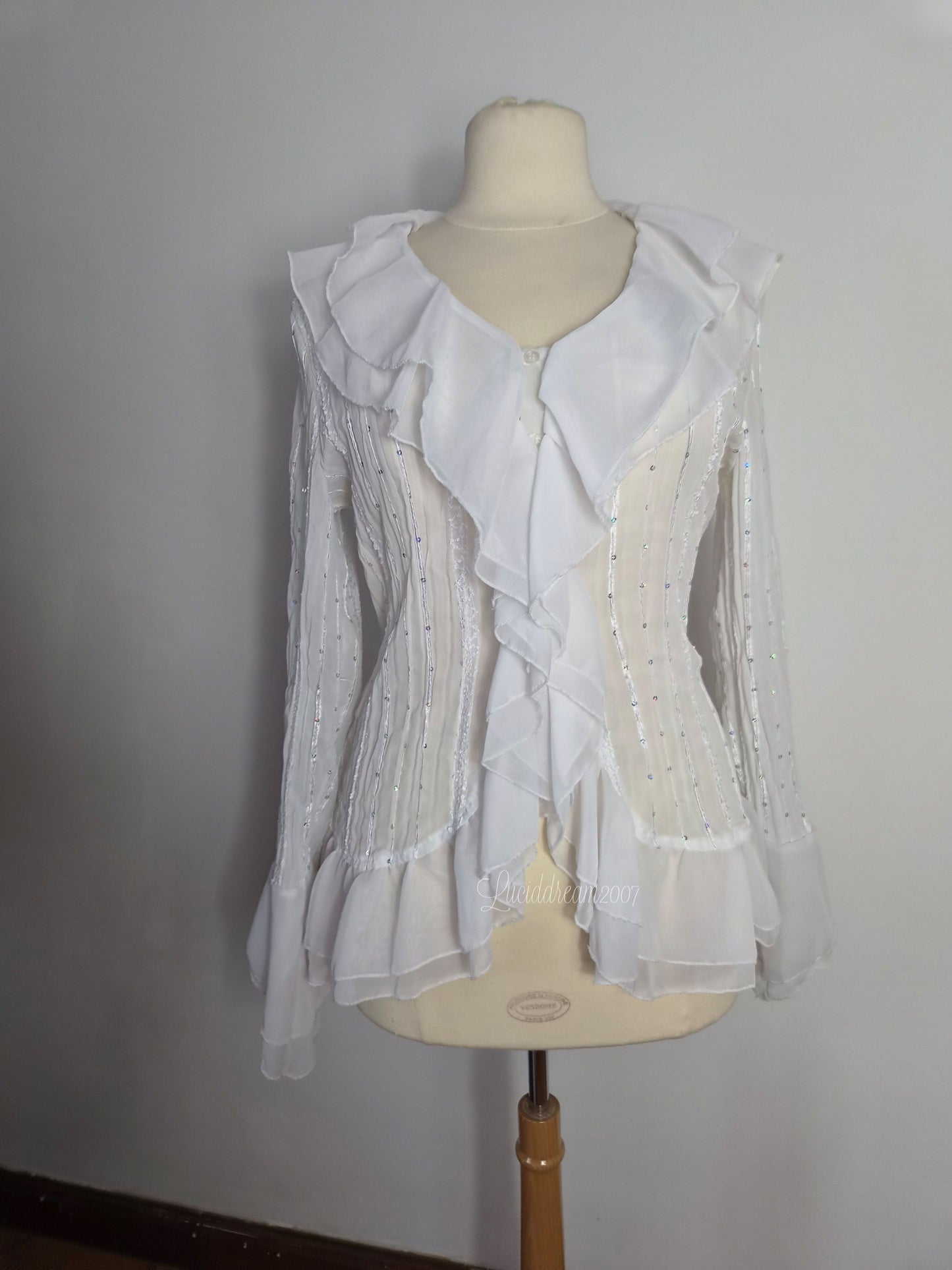 Blusa blanca con volantes y detalles de lentejuelas