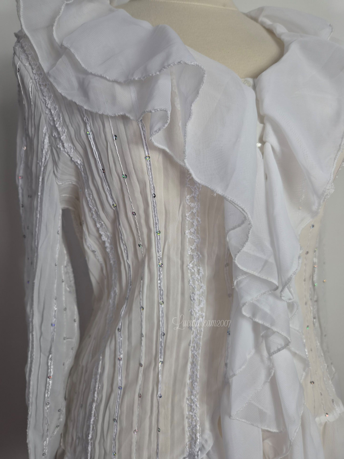 Blusa blanca con volantes y detalles de lentejuelas