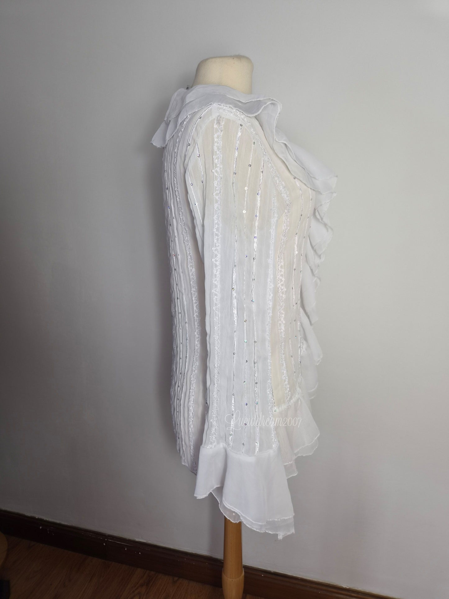 Blusa blanca con volantes y detalles de lentejuelas