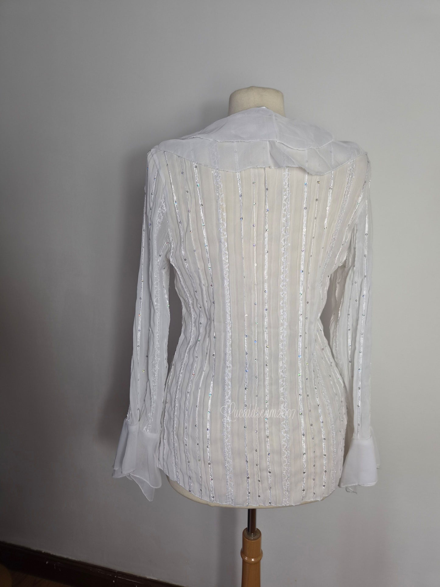 Blusa blanca con volantes y detalles de lentejuelas