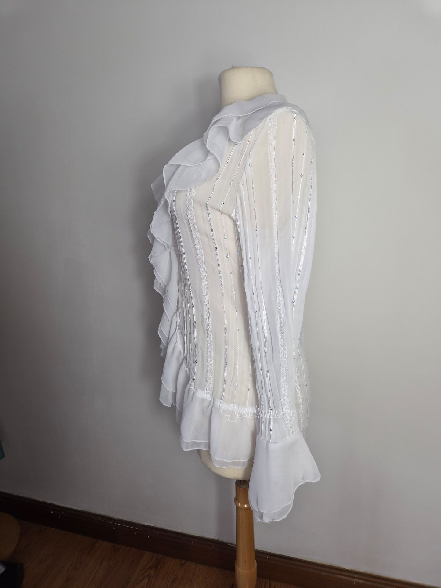 Blusa blanca con volantes y detalles de lentejuelas
