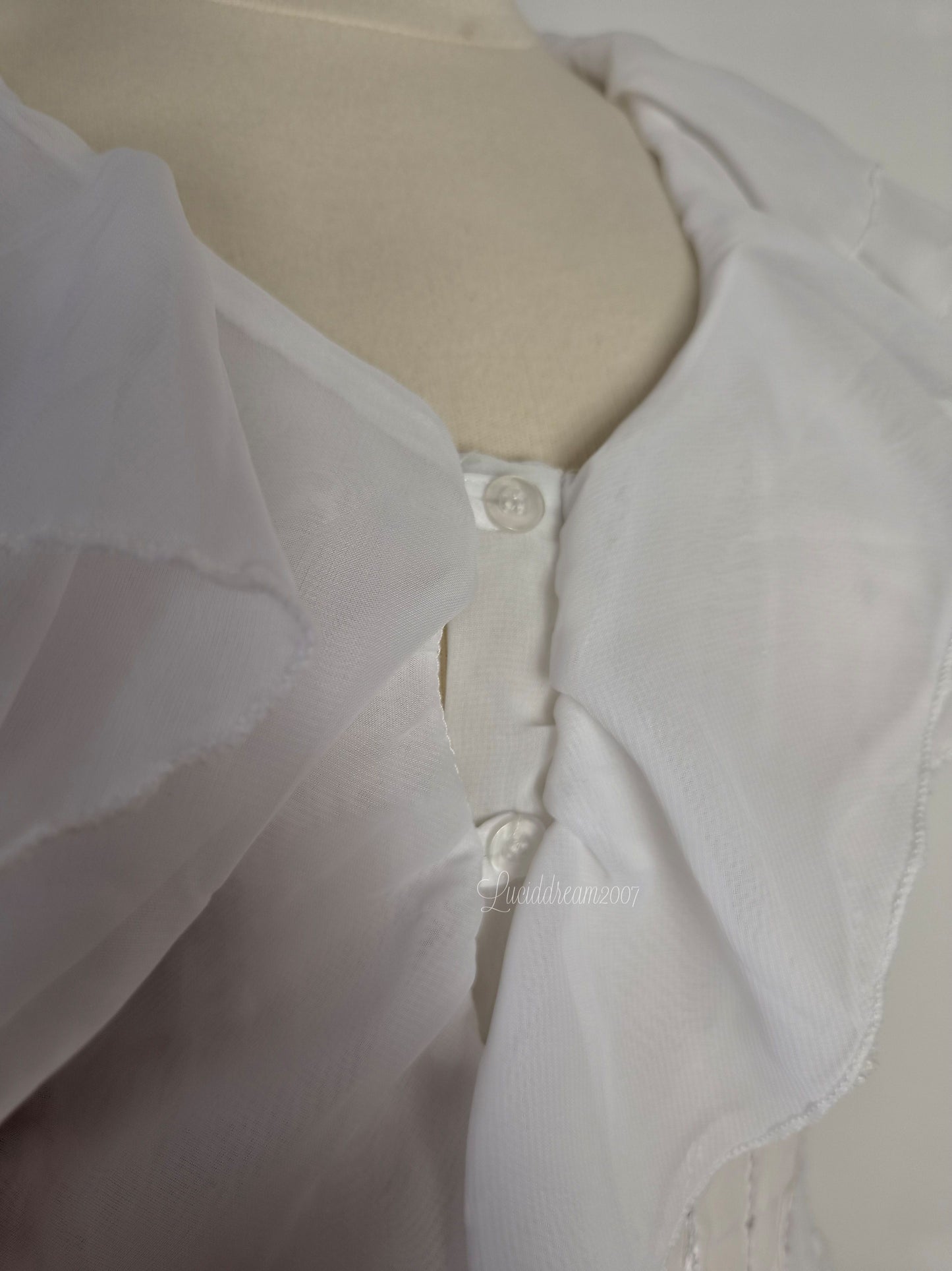 Blusa blanca con volantes y detalles de lentejuelas