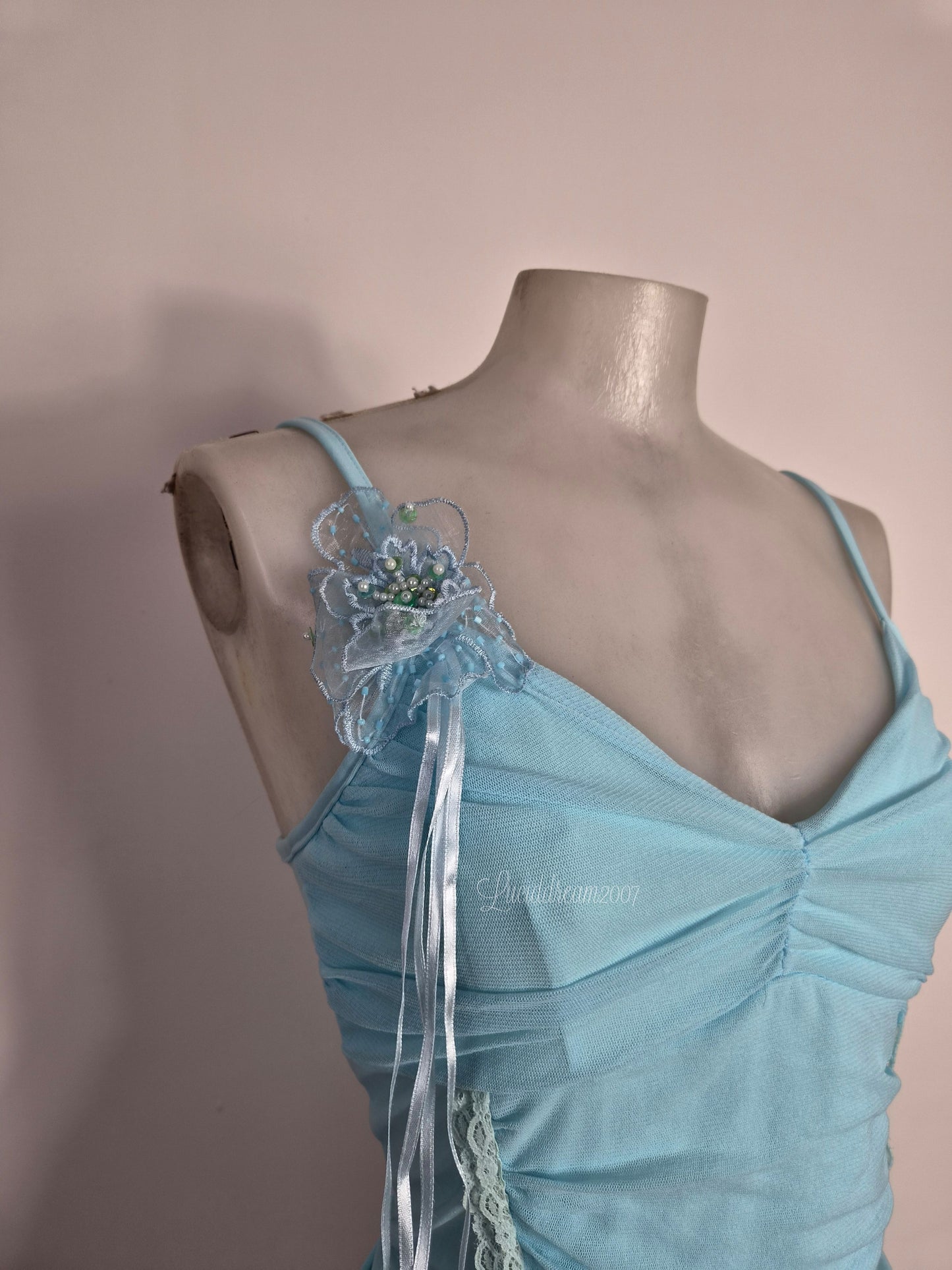 Haut bleu détails fleurs 3D